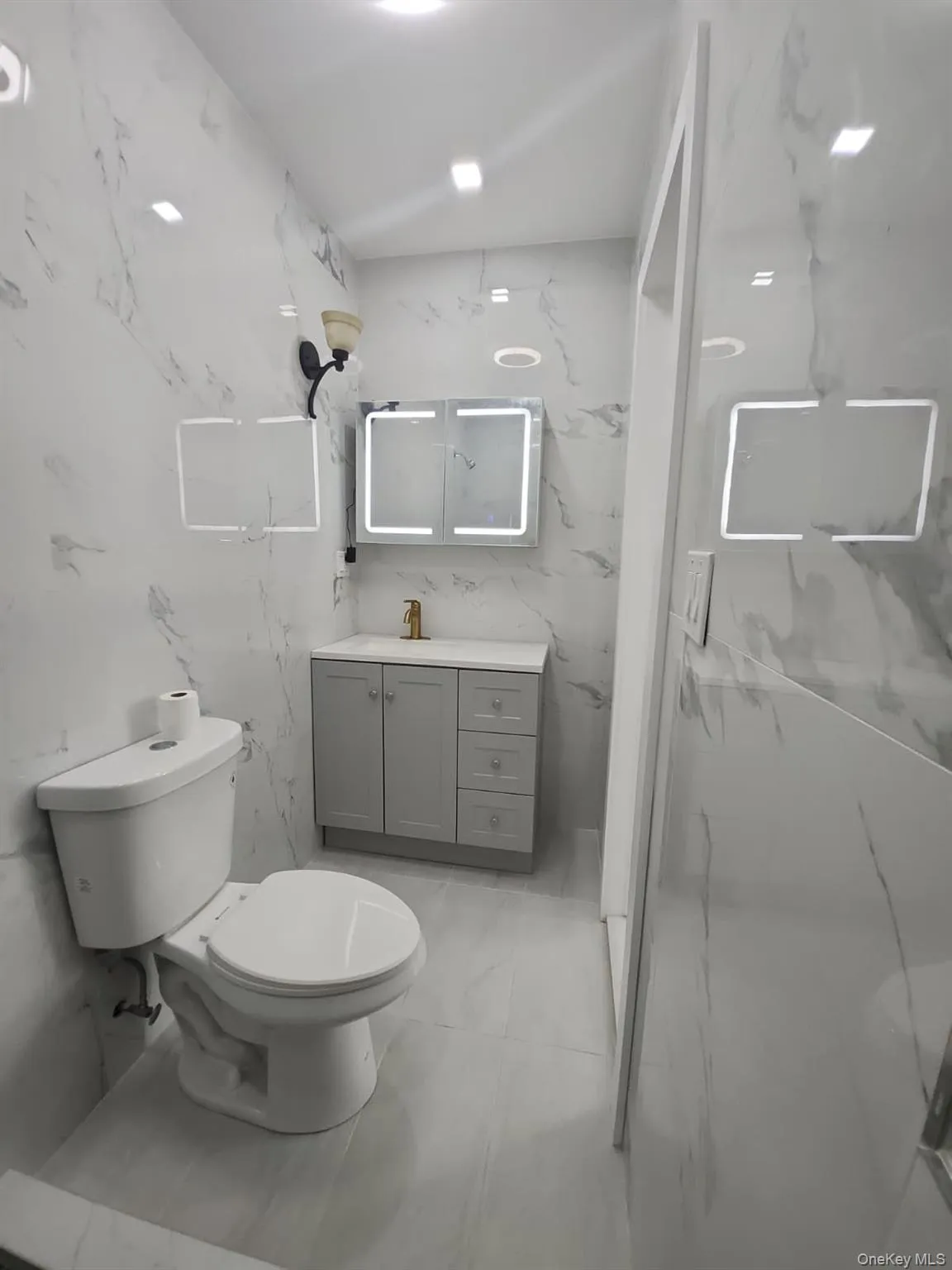 Bathroom with vanity, stone wall, and a marble finish shower Bathroom with vanity, stone wall, and a marble finish shower