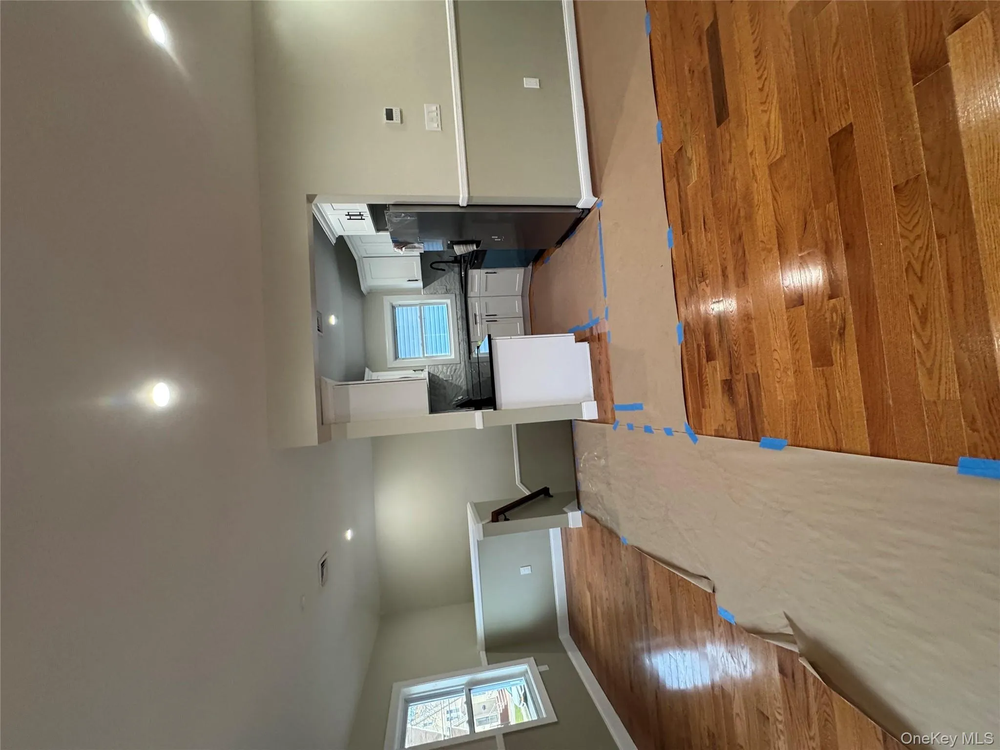 Kitchen with open floor plan, white cabinetry, recessed lighting, light wood-style floors, and refrigerator Kitchen with open floor plan, white cabinetry, recessed lighting, light wood-style floors, and refrigerator