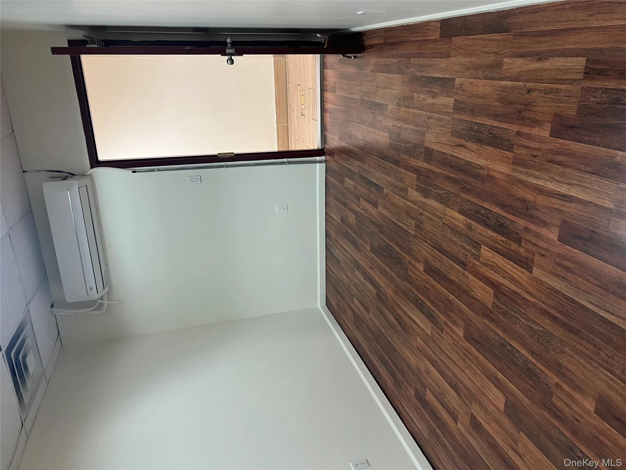 Spare room featuring a paneled ceiling, dark wood finished floors, and a wall mounted air conditioner Spare room featuring a paneled ceiling, dark wood finished floors, and a wall mounted air conditioner