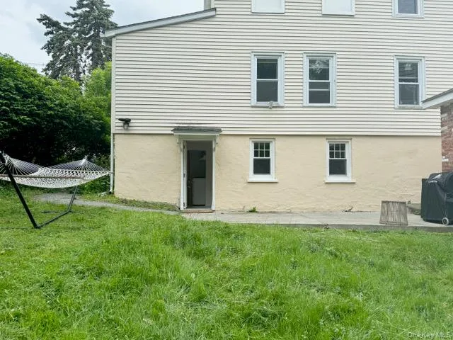 Back of property with a yard and stucco siding Back of property with a yard and stucco siding