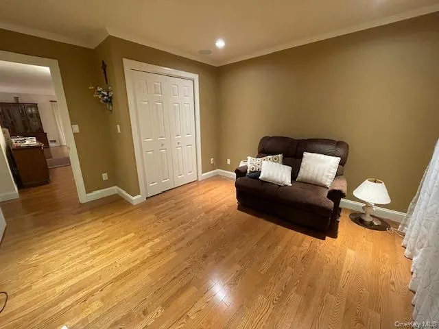 Second bedroom featuring ornamental molding, light wood-type flooring, and recessed lighting Second bedroom featuring ornamental molding, light wood-type flooring, and recessed lighting