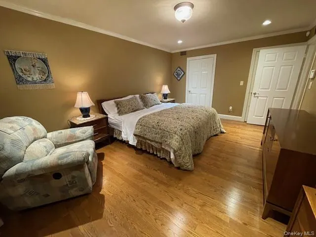 Bedroom with light wood-style flooring, crown molding, and recessed lighting Bedroom with light wood-style flooring, crown molding, and recessed lighting