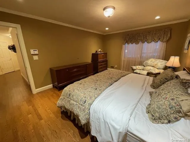 Bedroom with ornamental molding, wood finished floors, and recessed lighting Bedroom with ornamental molding, wood finished floors, and recessed lighting