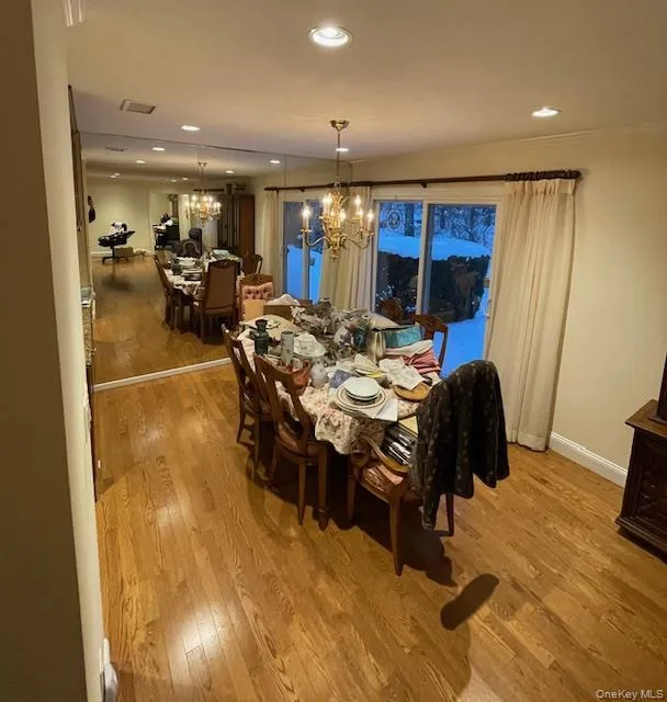 Dining space featuring light wood-style floors, a chandelier, and recessed lighting Dining space featuring light wood-style floors, a chandelier, and recessed lighting