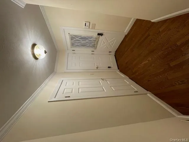 Corridor featuring ornamental molding and dark wood-type flooring Corridor featuring ornamental molding and dark wood-type flooring