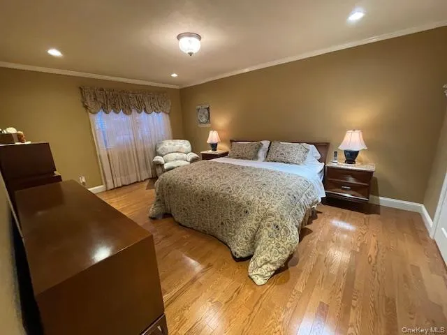 Bedroom featuring light wood finished floors, recessed lighting, and ornamental molding Bedroom featuring light wood finished floors, recessed lighting, and ornamental molding