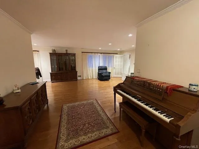 Sitting room with light wood-type flooring, crown molding, and recessed lighting Sitting room with light wood-type flooring, crown molding, and recessed lighting