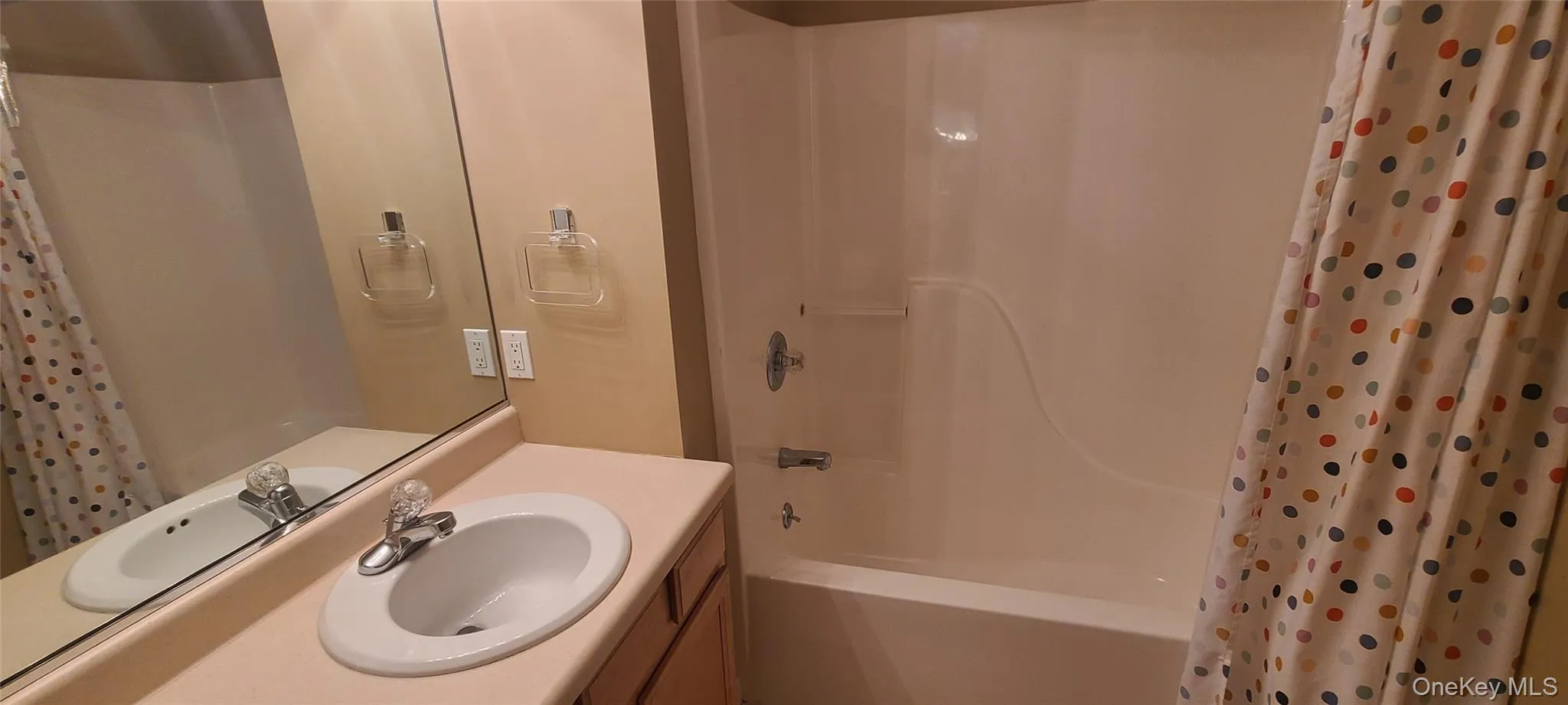 Bathroom featuring vanity and shower / bathtub combination with curtain Bathroom featuring vanity and shower / bathtub combination with curtain