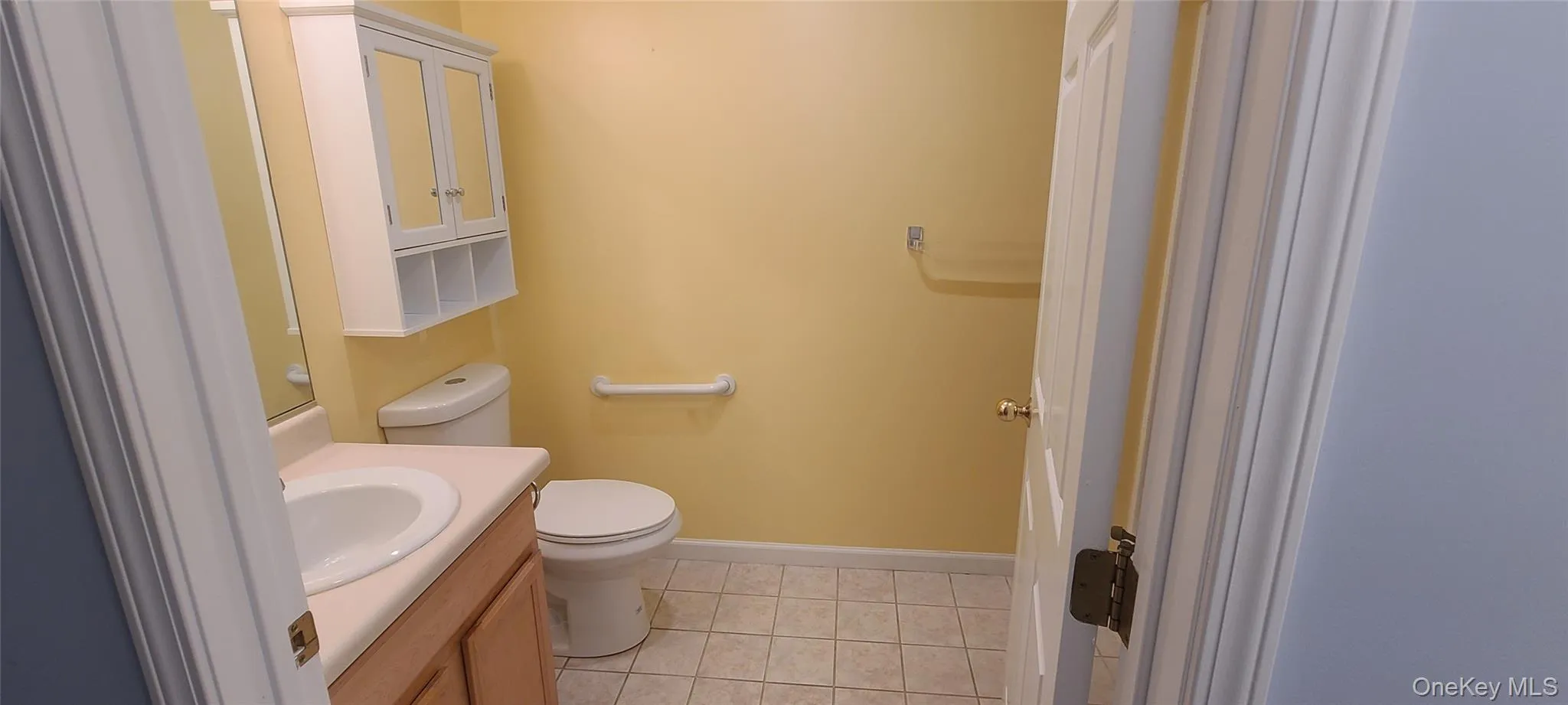 Bathroom featuring toilet, vanity, and tile patterned floors Bathroom featuring toilet, vanity, and tile patterned floors