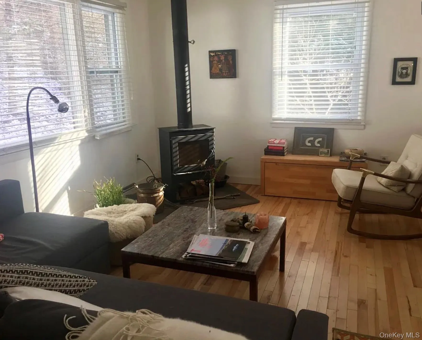Living room with a wood stove and wood-type flooring Living room with a wood stove and wood-type flooring