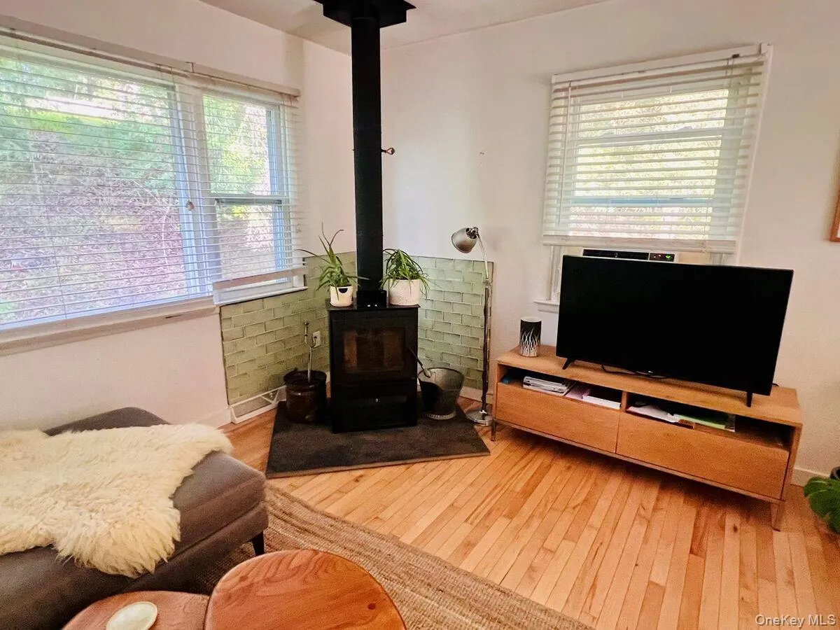 Living room with a wood stove and hardwood / wood-style flooring Living room with a wood stove and hardwood / wood-style flooring