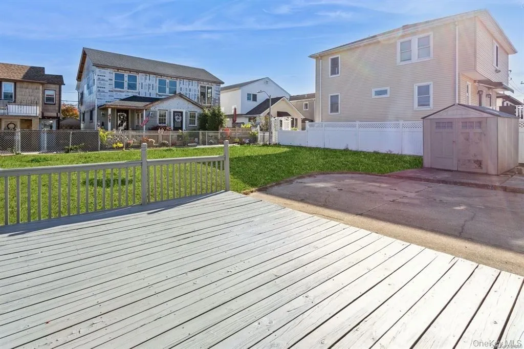 Deck featuring a residential view, a storage shed, and a fenced backyard Deck featuring a residential view, a storage shed, and a fenced backyard