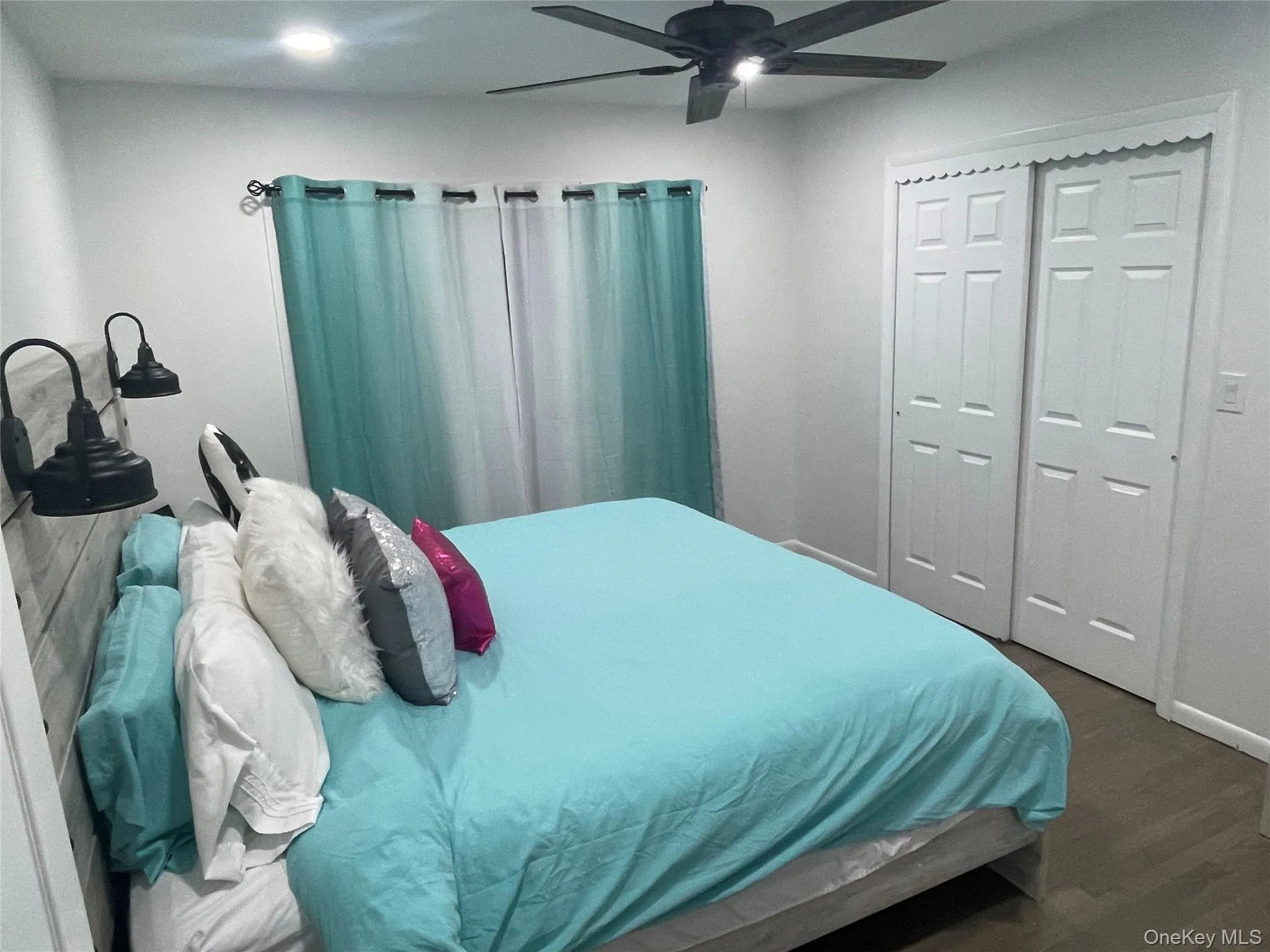 Bedroom featuring ceiling fan, wood finished floors, and a closet Bedroom featuring ceiling fan, wood finished floors, and a closet