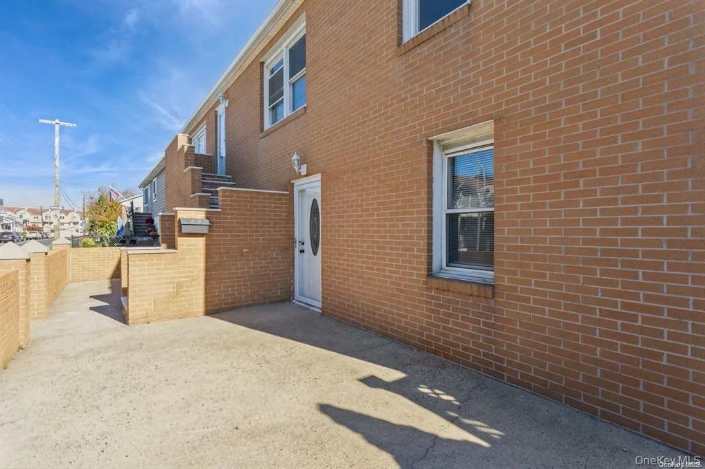 View of side of property with brick siding and a patio area View of side of property with brick siding and a patio area