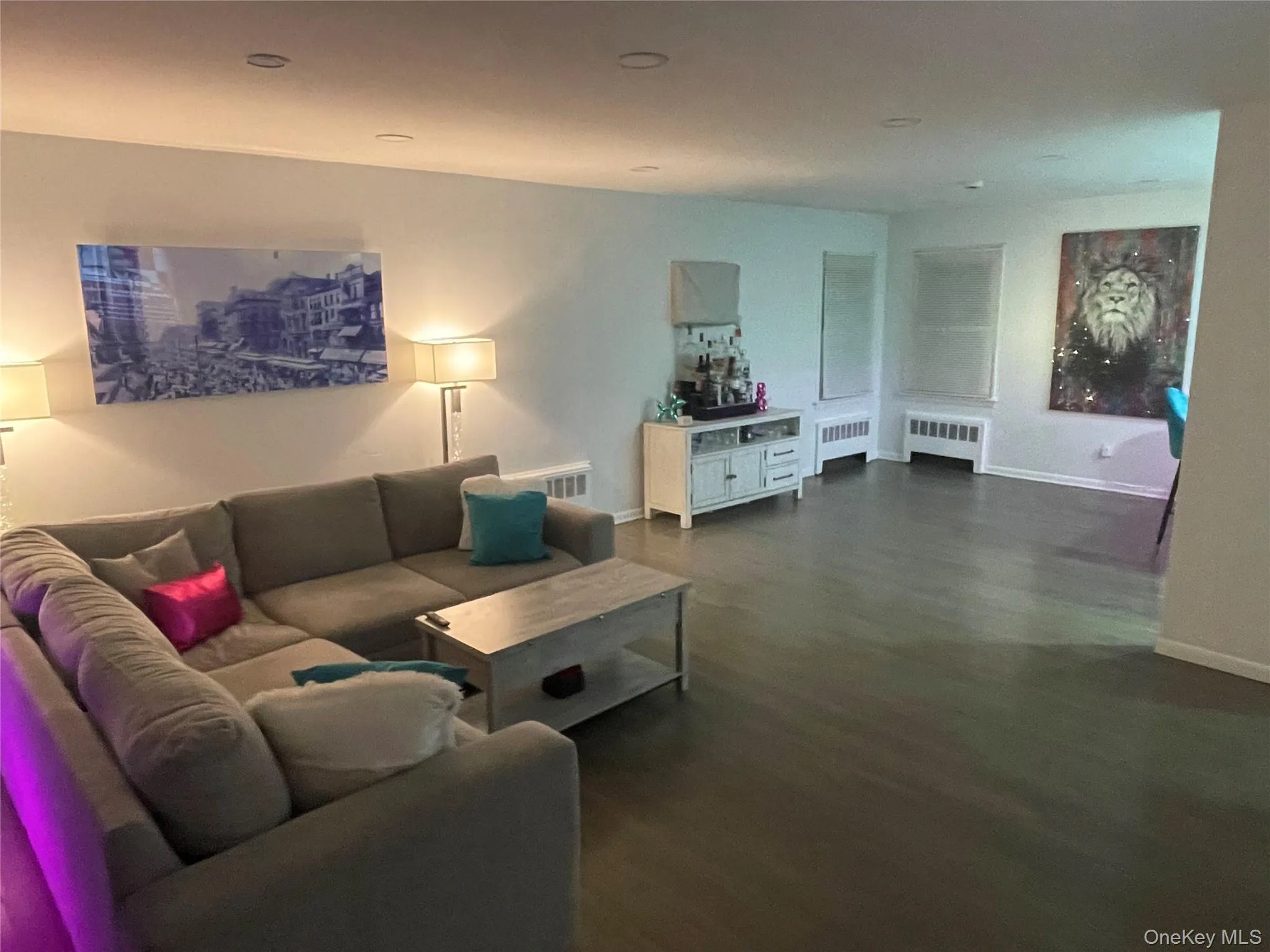 Living room featuring radiator heating unit and dark wood-style floors Living room featuring radiator heating unit and dark wood-style floors
