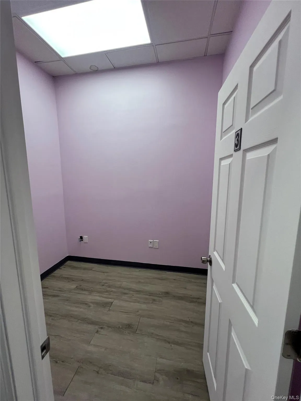 Empty room with a paneled ceiling and wood finished floors Empty room with a paneled ceiling and wood finished floors