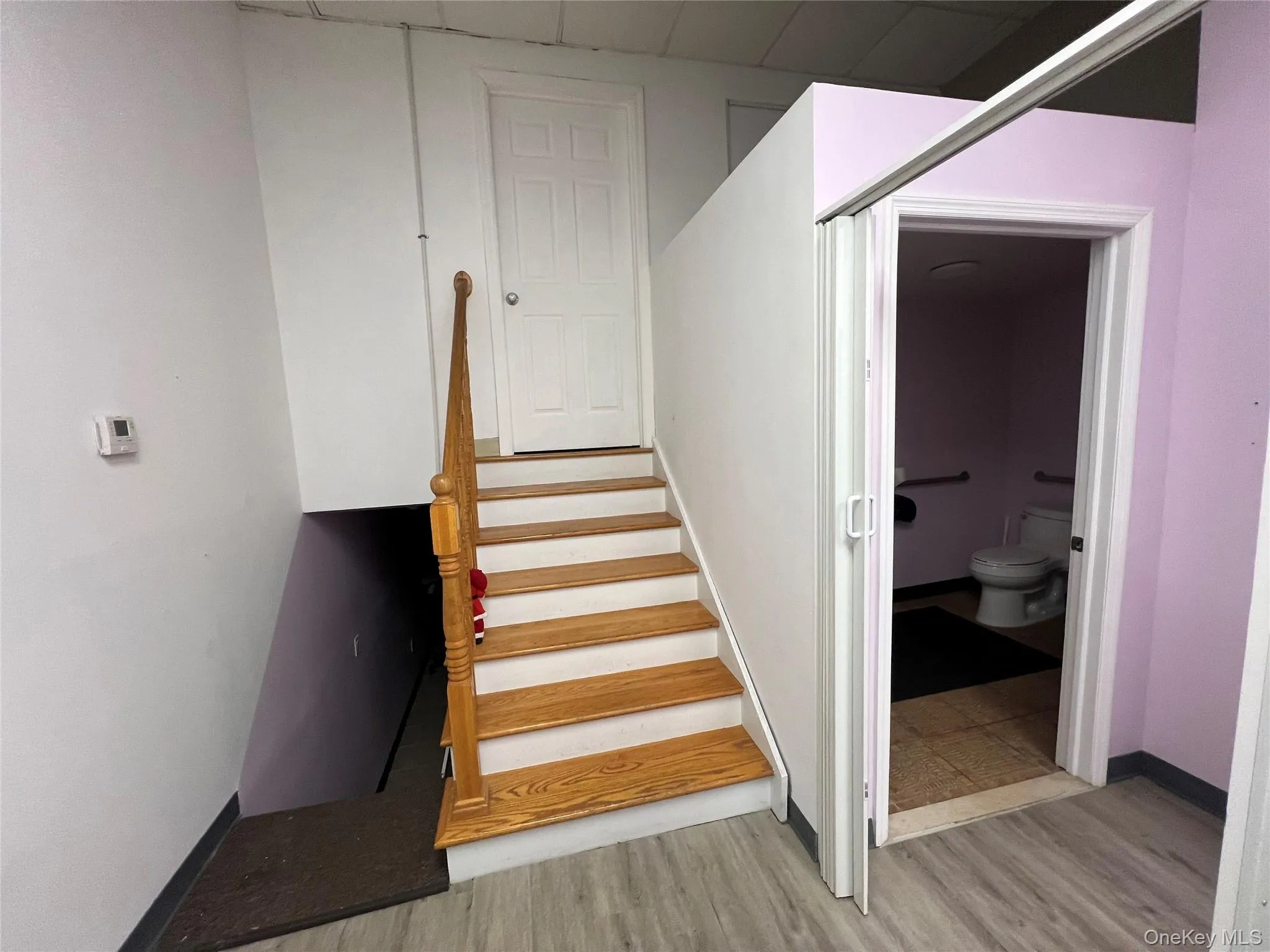 Staircase featuring wood finished floors Staircase featuring wood finished floors