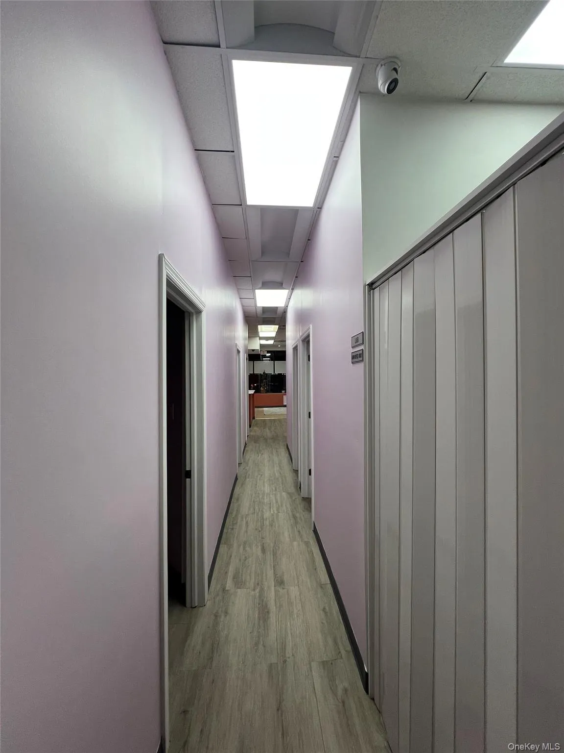 Hall with a paneled ceiling and light wood finished floors Hall with a paneled ceiling and light wood finished floors