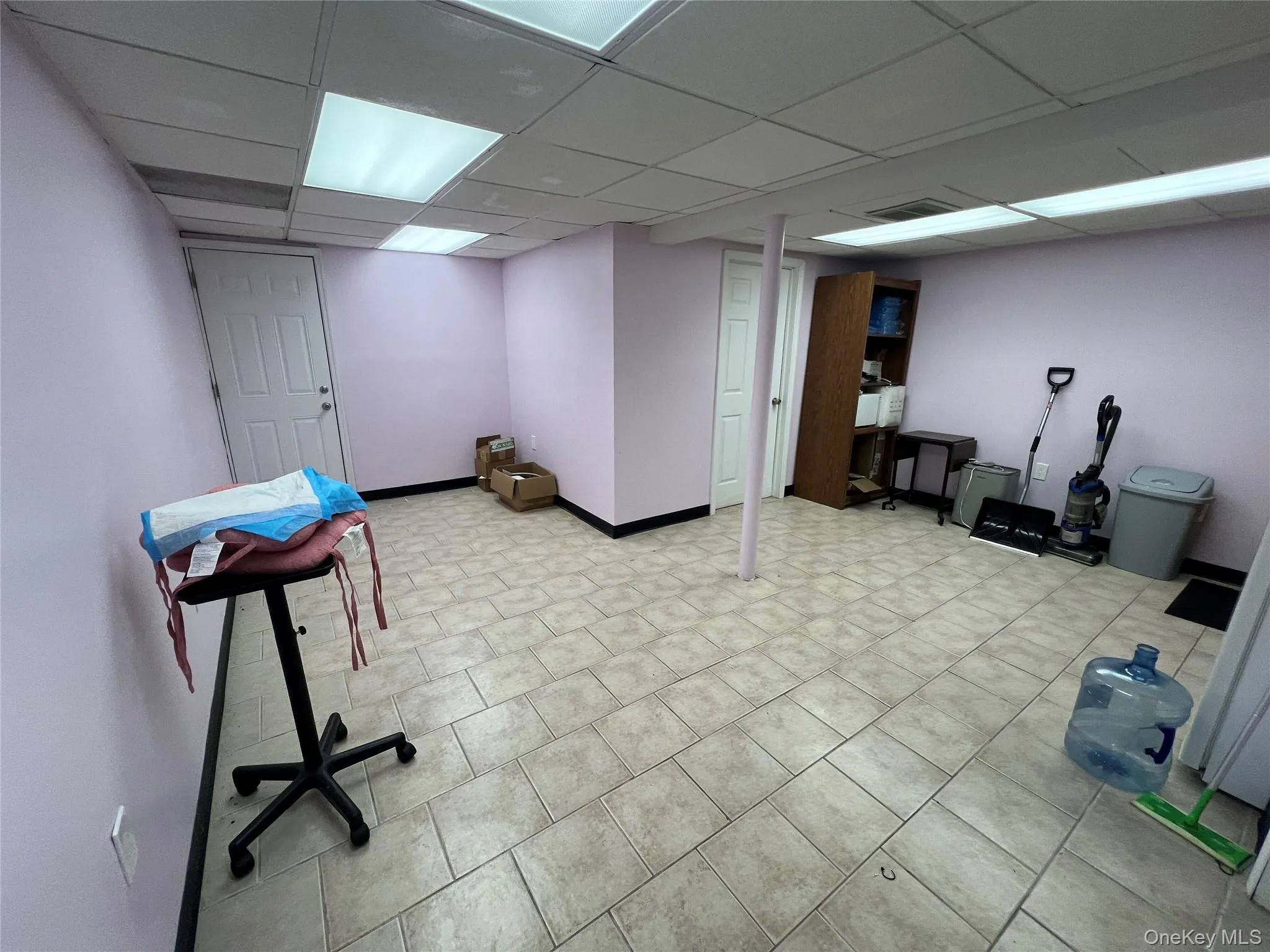 Finished below grade area featuring a paneled ceiling and light tile patterned floors Finished below grade area featuring a paneled ceiling and light tile patterned floors