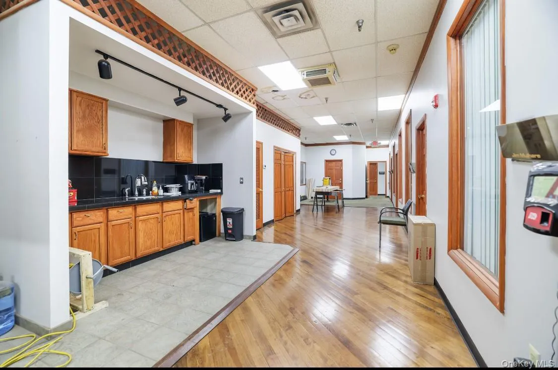 Kitchen featuring dark countertops, visible vents, tasteful backsplash, and a drop ceiling Kitchen featuring dark countertops, visible vents, tasteful backsplash, and a drop ceiling