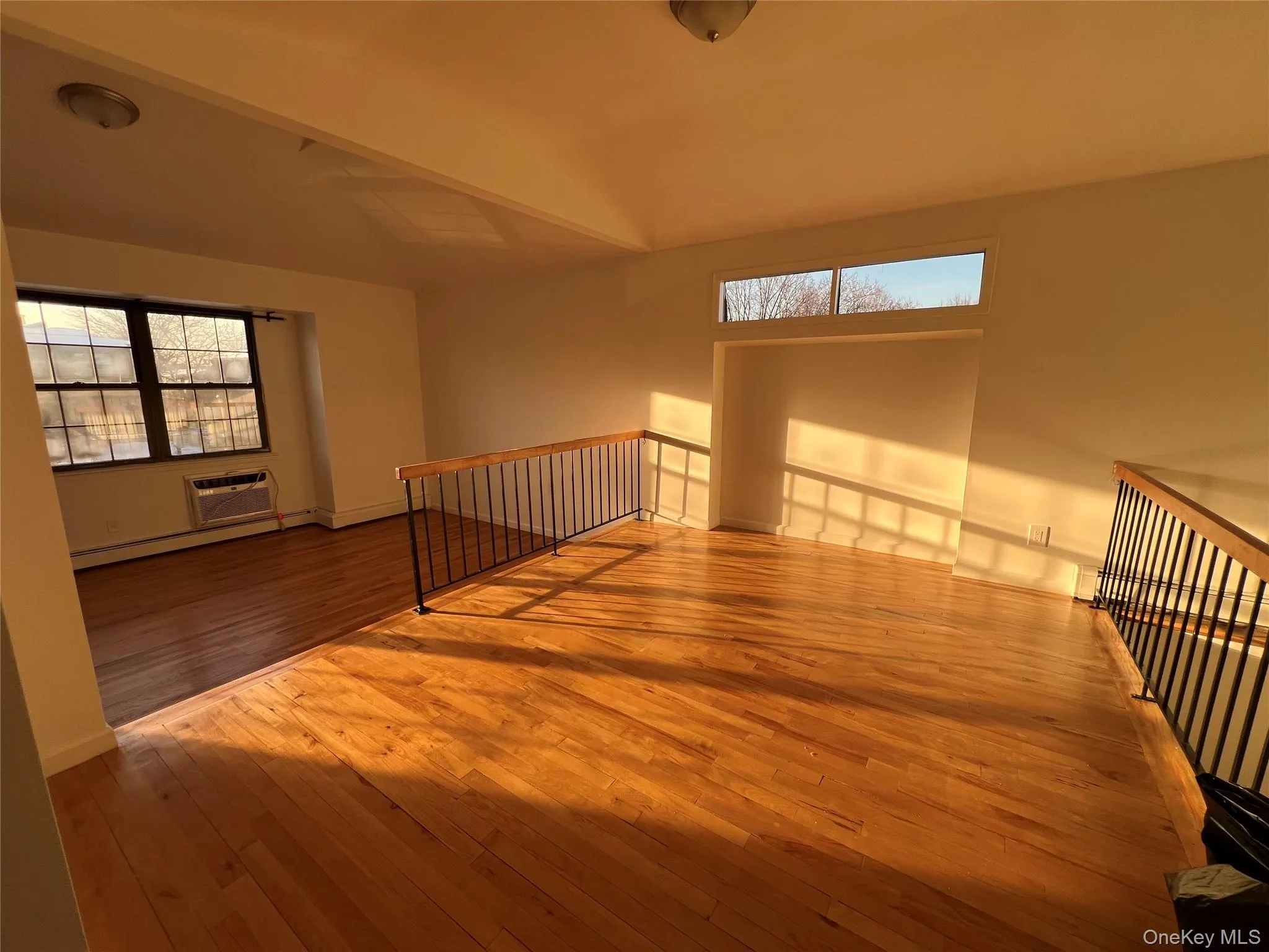 Unfurnished room with hardwood / wood-style flooring, plenty of natural light, and a wall unit AC Unfurnished room with hardwood / wood-style flooring, plenty of natural light, and a wall unit AC