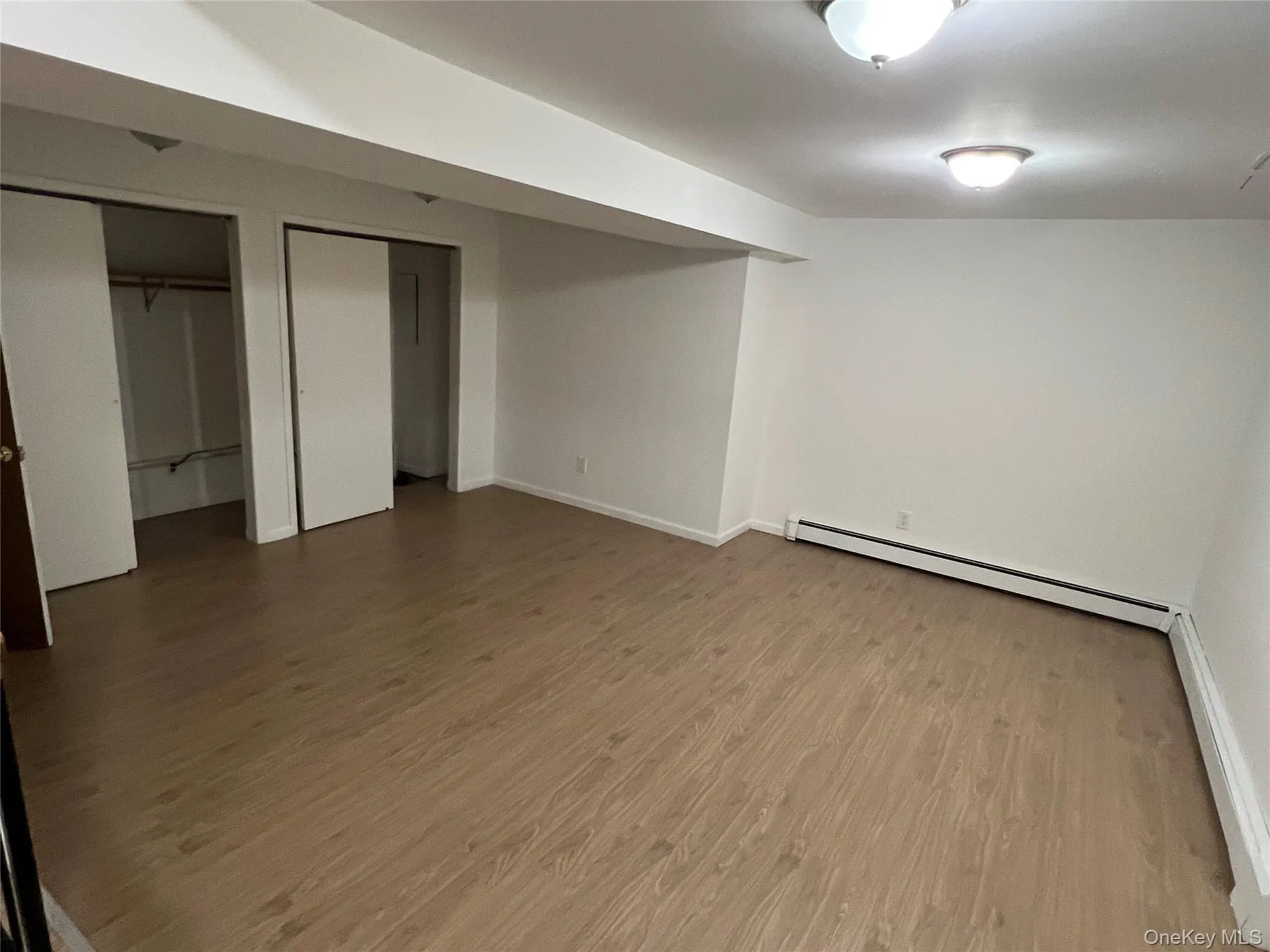 Finished below grade area with baseboard heating and wood finished floors Finished below grade area with baseboard heating and wood finished floors