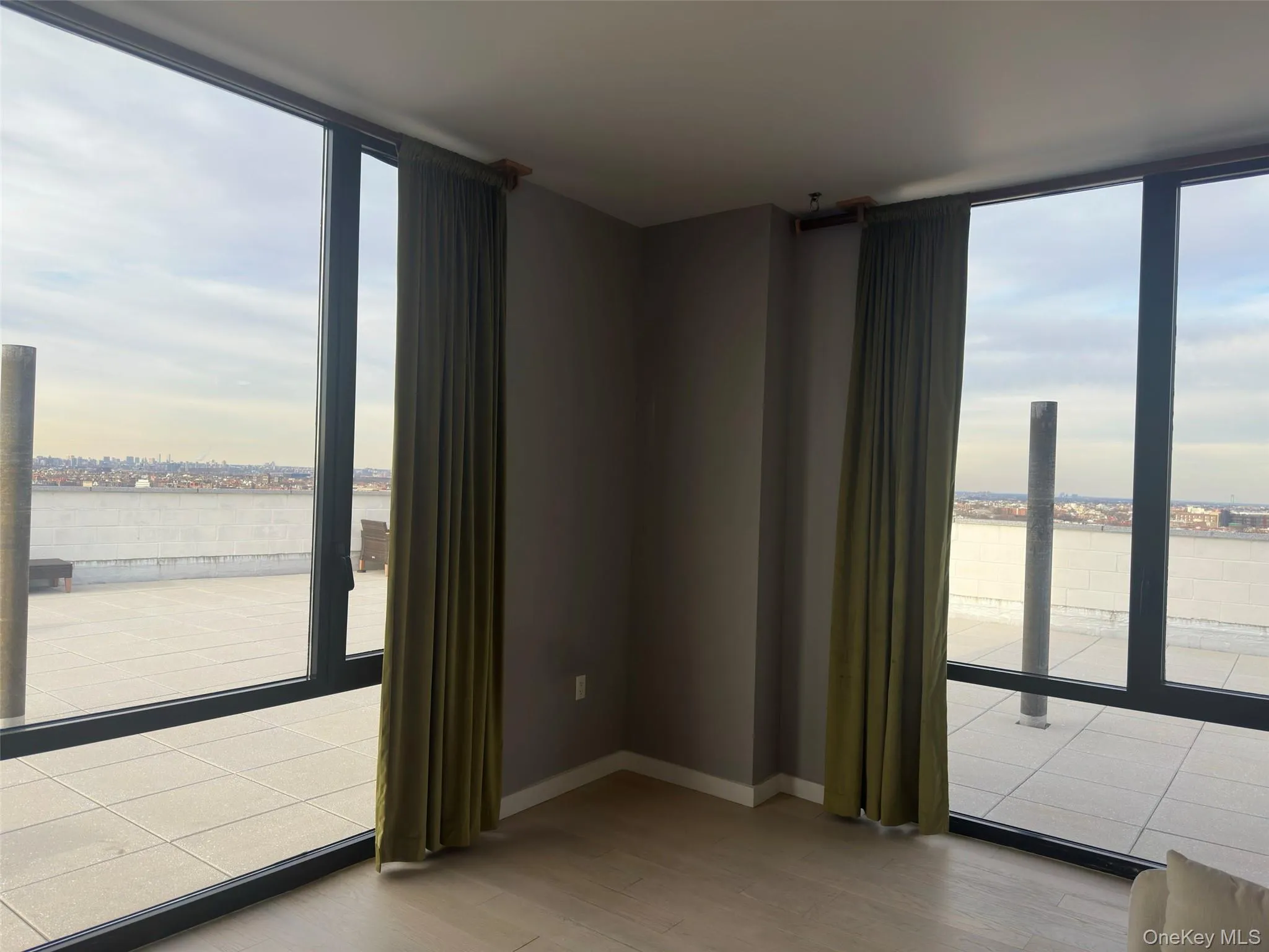 Unfurnished room featuring healthy amount of natural light, a water view, a wall of windows, and light wood-type flooring Unfurnished room featuring healthy amount of natural light, a water view, a wall of windows, and light wood-type flooring