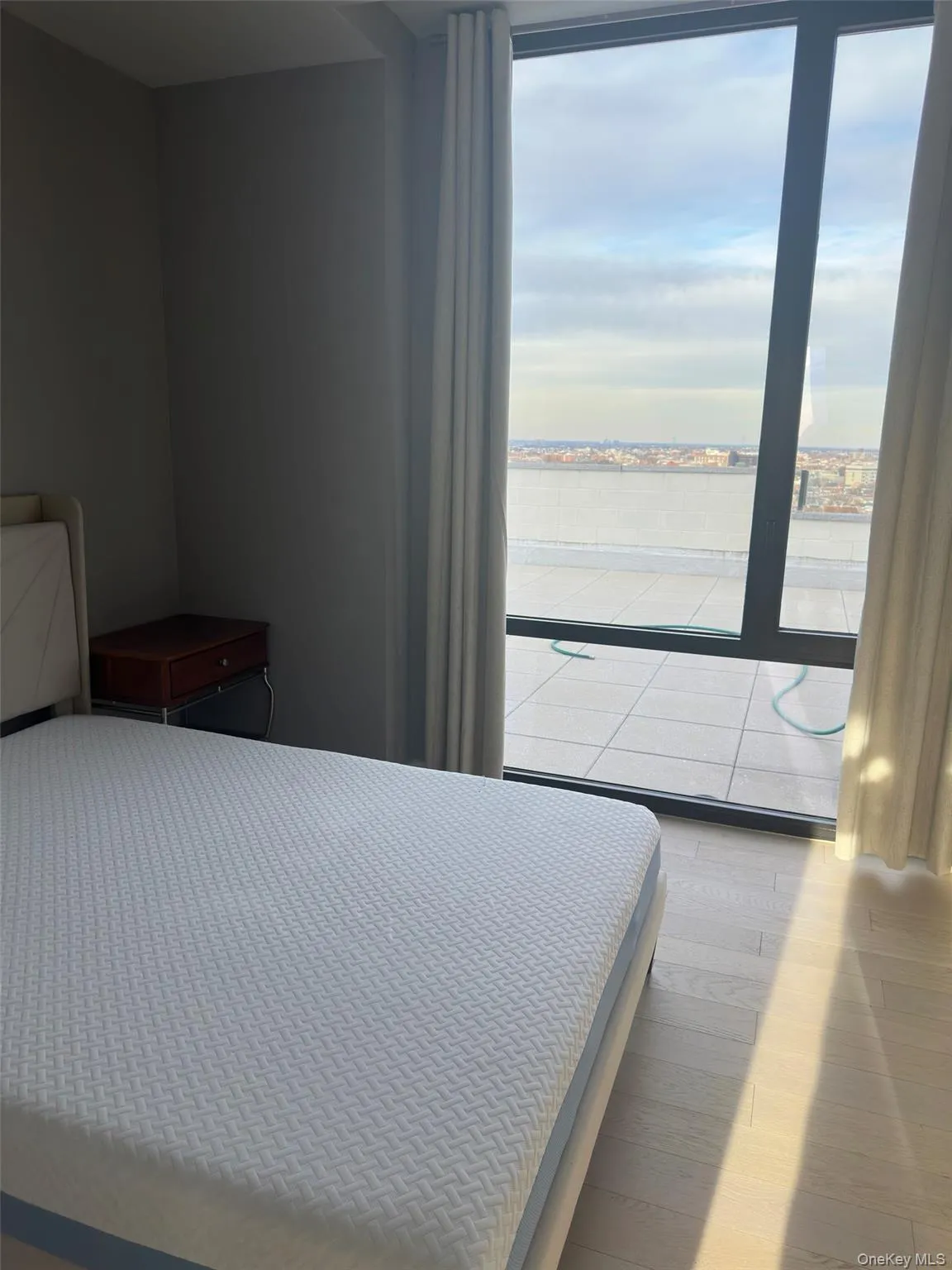 Bedroom with access to exterior, multiple windows, light wood-type flooring, and a water view Bedroom with access to exterior, multiple windows, light wood-type flooring, and a water view