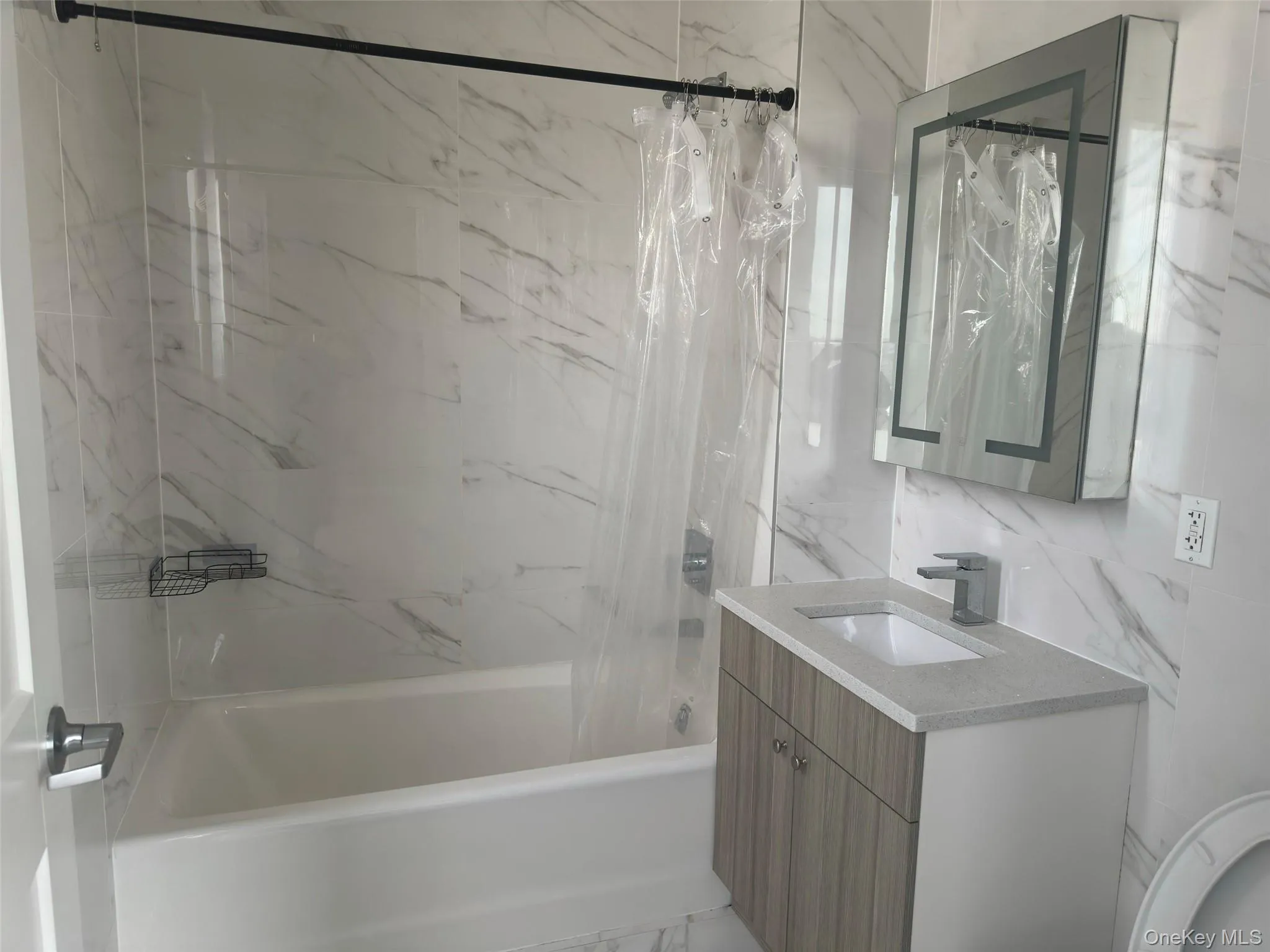 Full bath with shower / bath combo, vanity, and tile walls Full bath with shower / bath combo, vanity, and tile walls