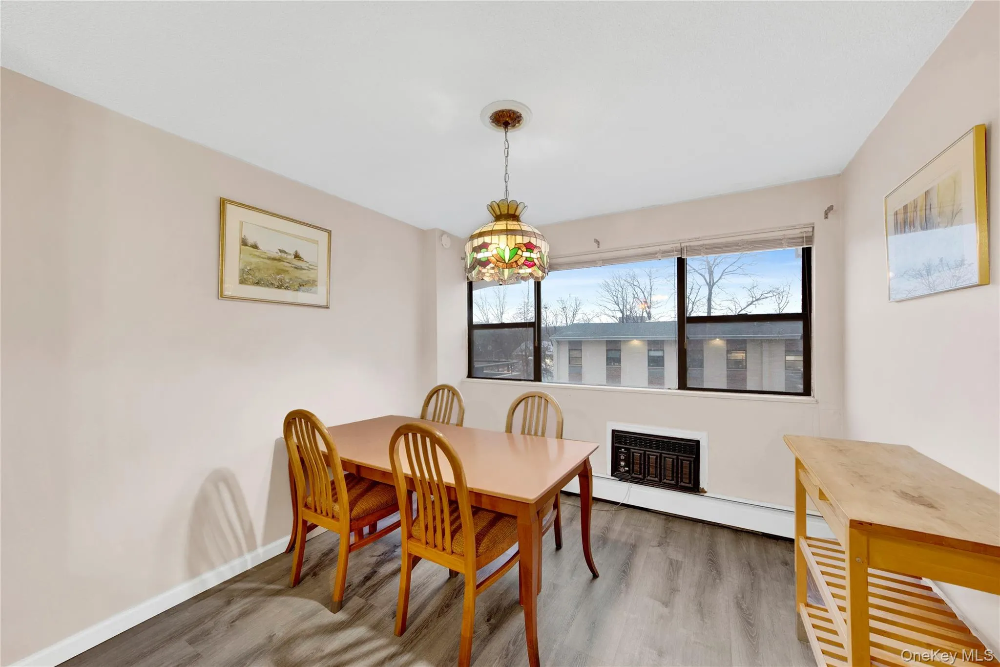 Dining room featuring a baseboard heating unit and light wood-style flooring Dining room featuring a baseboard heating unit and light wood-style flooring