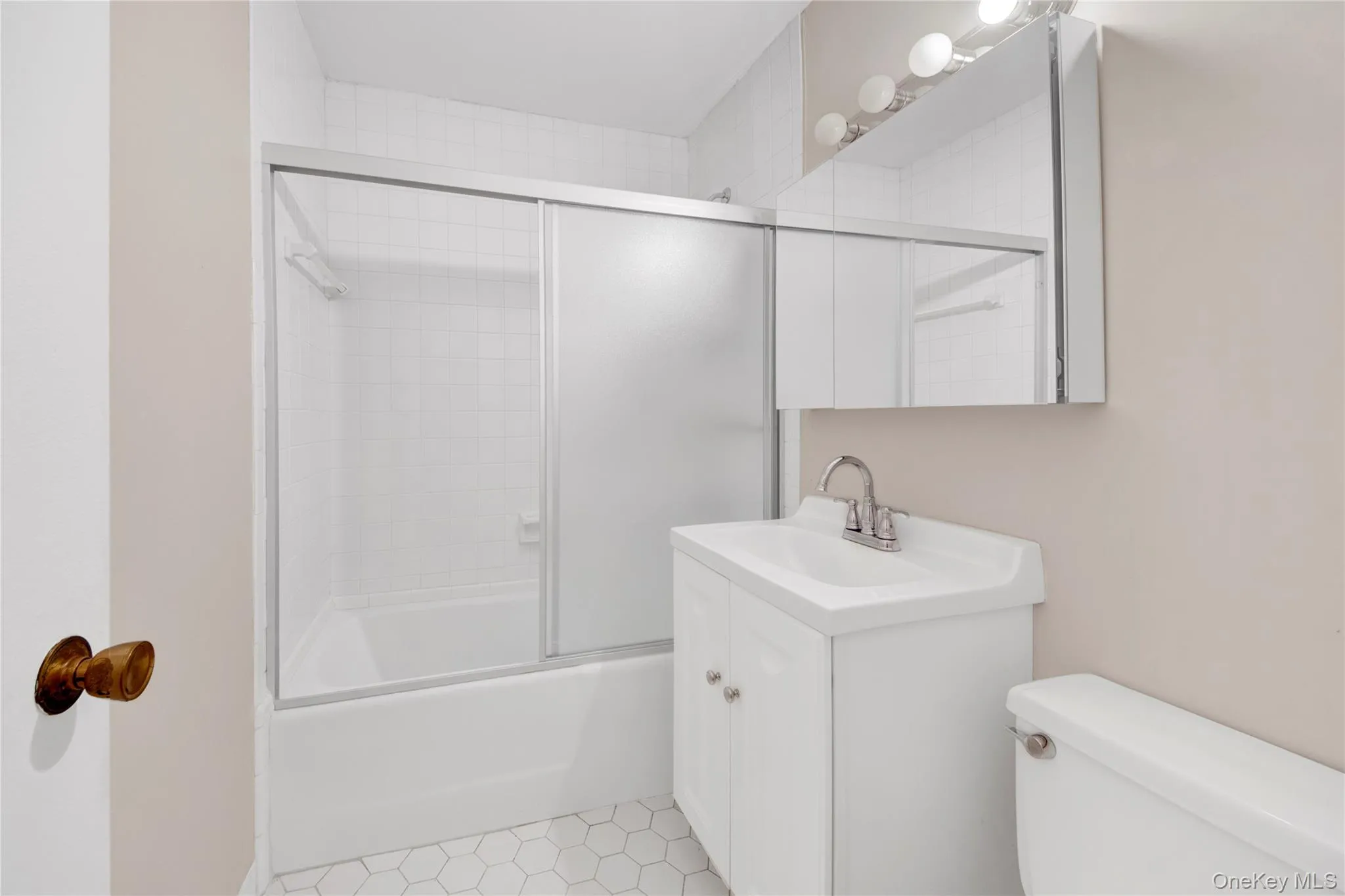Bathroom featuring bath / shower combo with glass door and vanity Bathroom featuring bath / shower combo with glass door and vanity