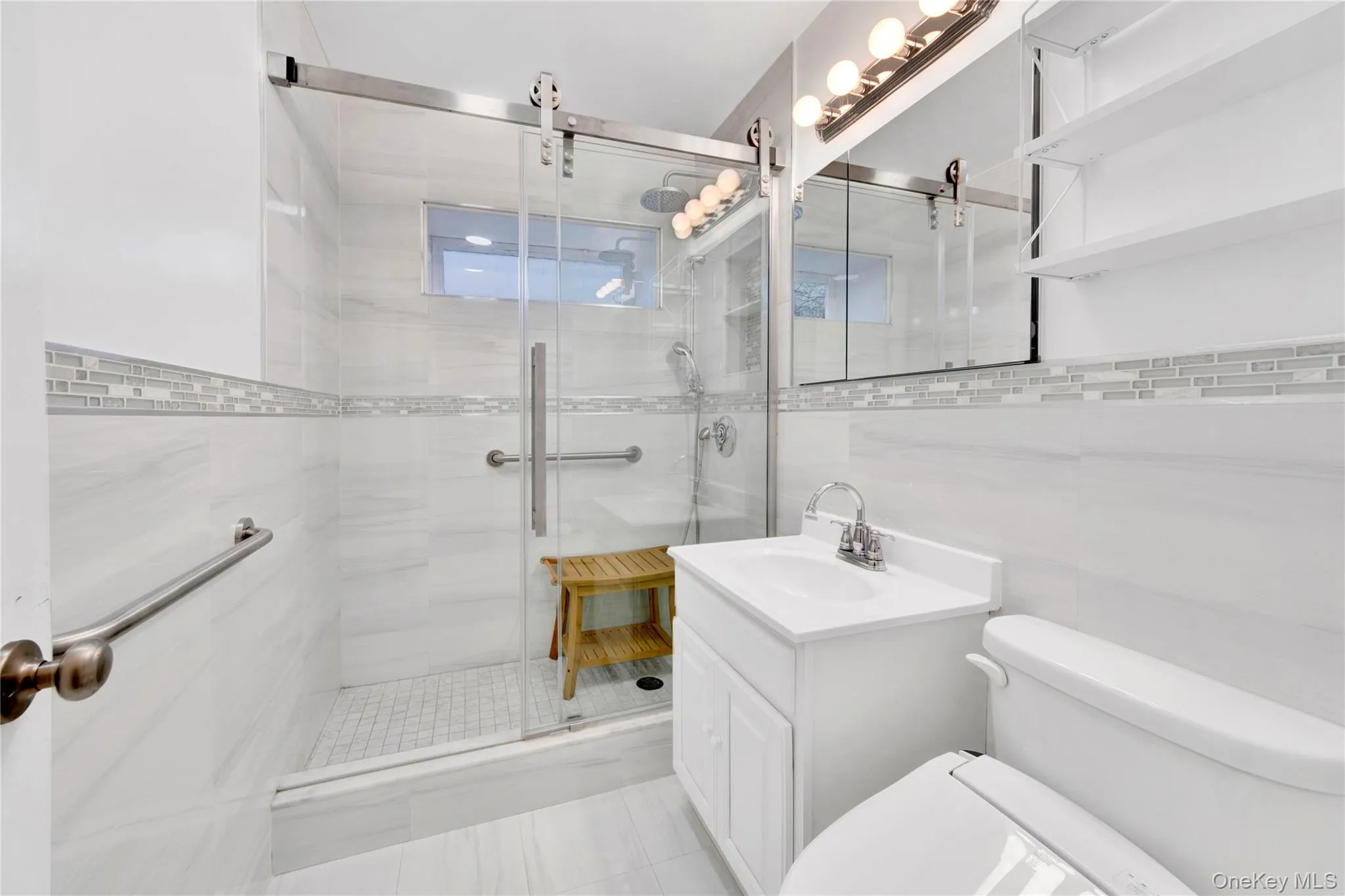 Full bath featuring vanity, a stall shower, and tile walls Full bath featuring vanity, a stall shower, and tile walls