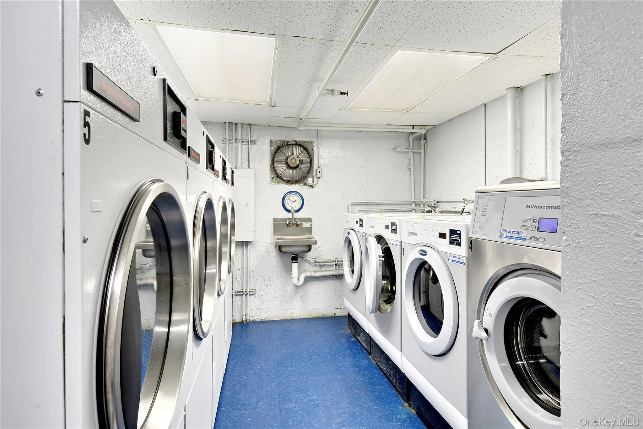 Community laundry with a paneled ceiling and washing machine and clothes dryer Community laundry with a paneled ceiling and washing machine and clothes dryer