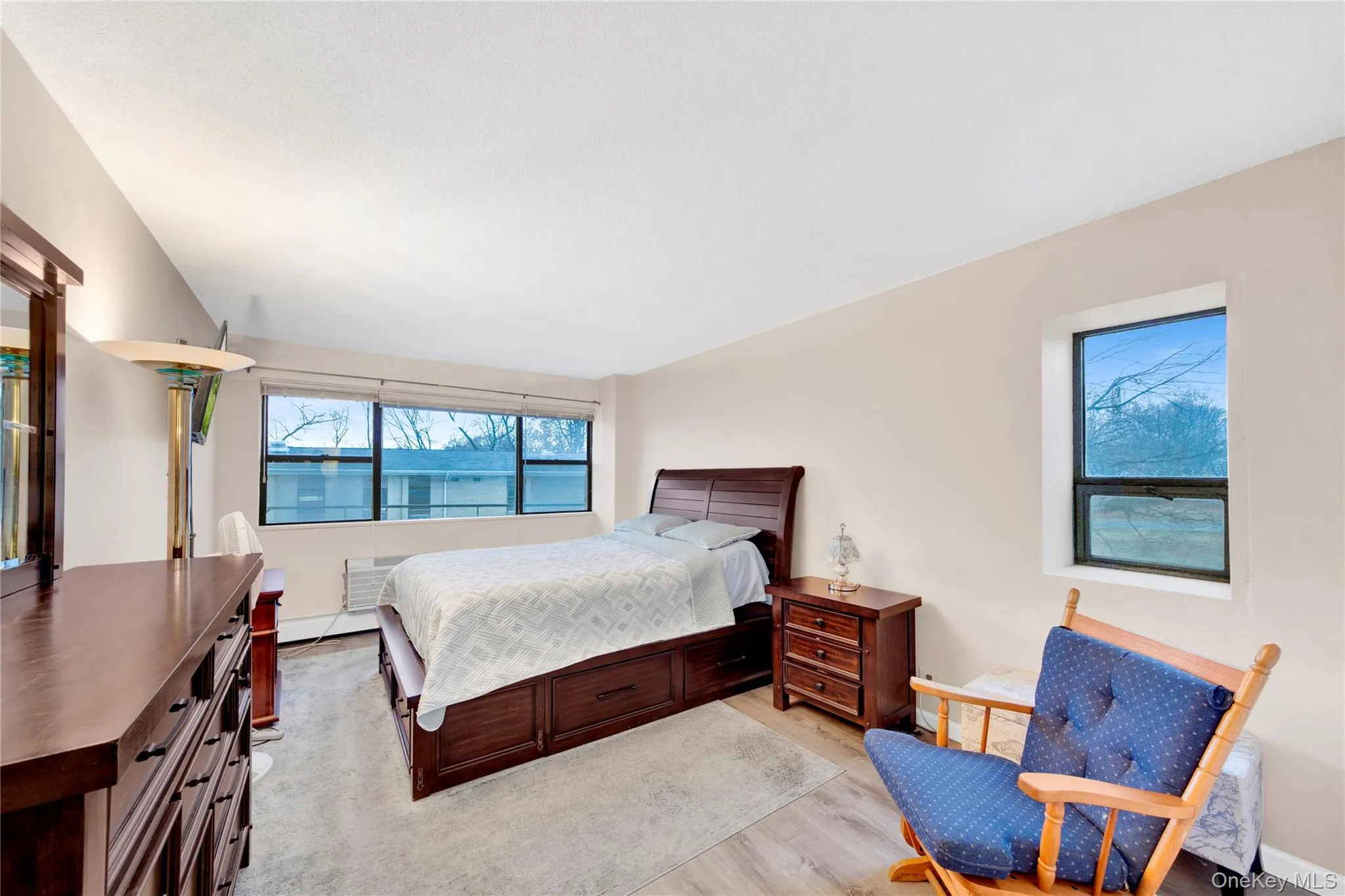 Bedroom with light wood-style flooring and baseboard heating Bedroom with light wood-style flooring and baseboard heating