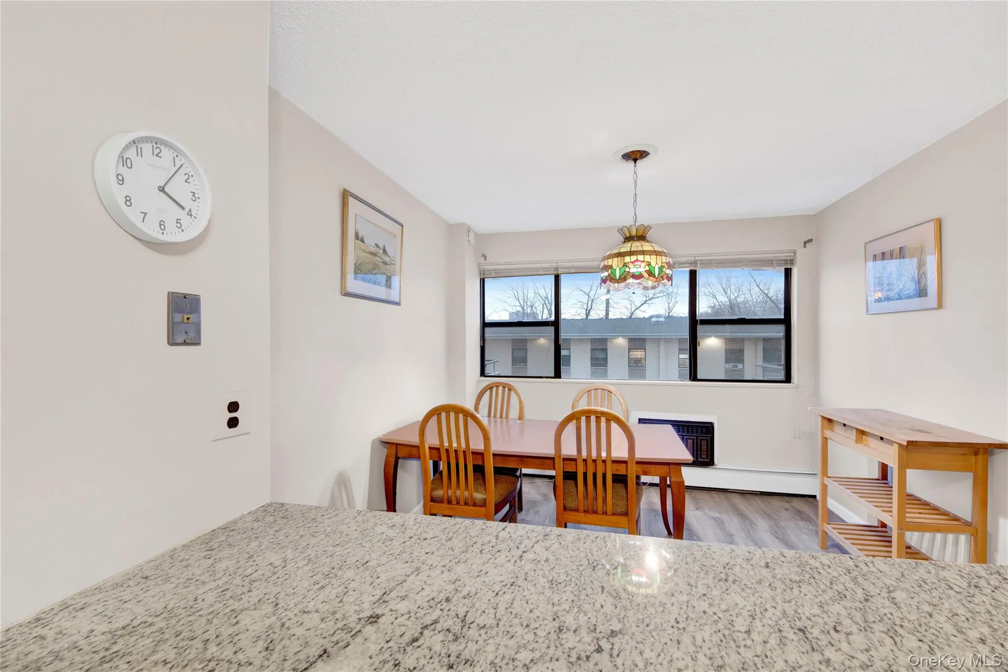Dining area with light wood finished floors and a baseboard heating unit Dining area with light wood finished floors and a baseboard heating unit