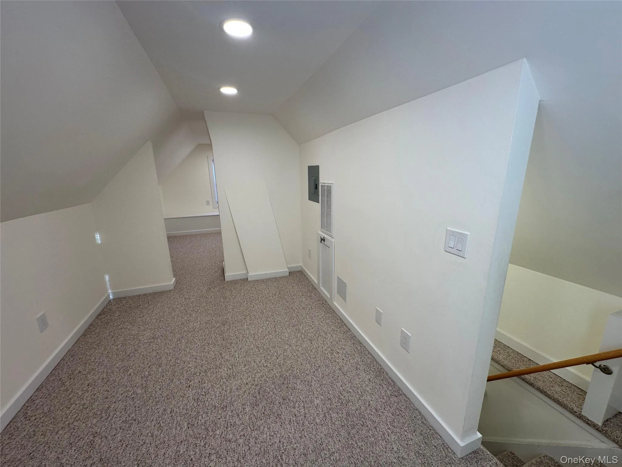 Attic for storage with vaulted ceiling, carpet flooring, and recessed lighting Attic for storage with vaulted ceiling, carpet flooring, and recessed lighting