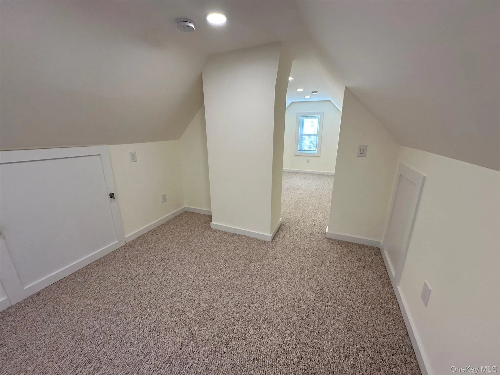 Attic for storage with vaulted ceiling, carpet flooring, and recessed lighting Attic for storage with vaulted ceiling, carpet flooring, and recessed lighting