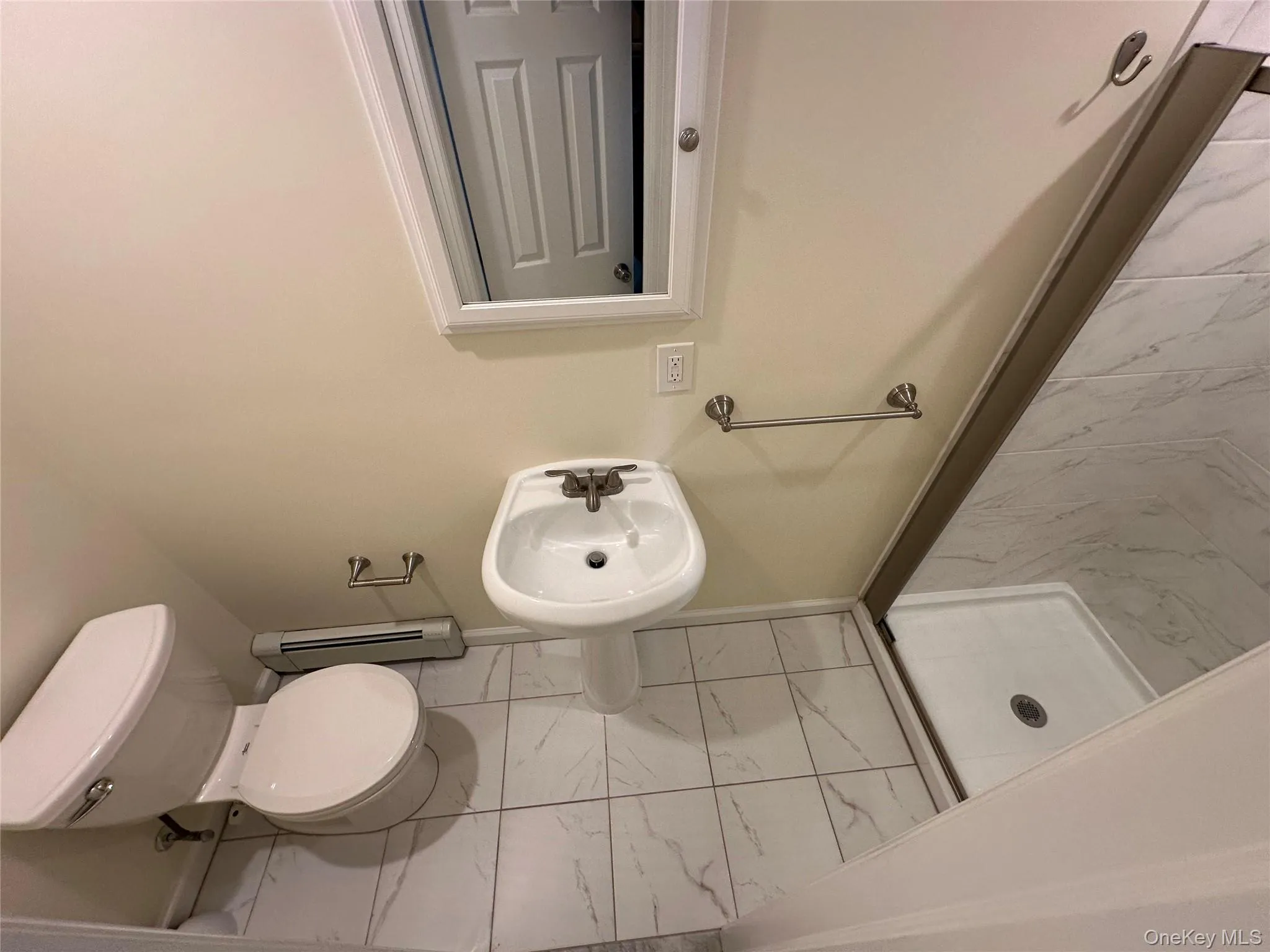 Renovated Full bathroom featuring light tile floors, a stall shower, and a baseboard radiator Renovated Full bathroom featuring light tile floors, a stall shower, and a baseboard radiator