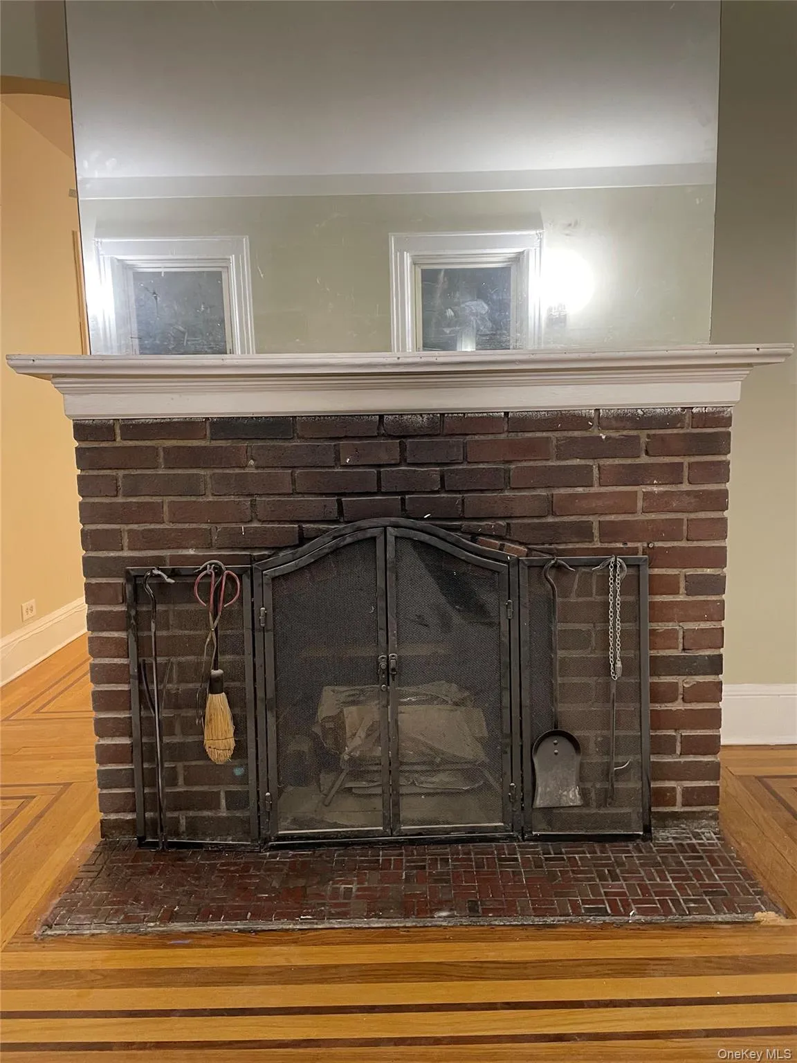 Detailed view of a brick fireplace and wood finished floors Detailed view of a brick fireplace and wood finished floors