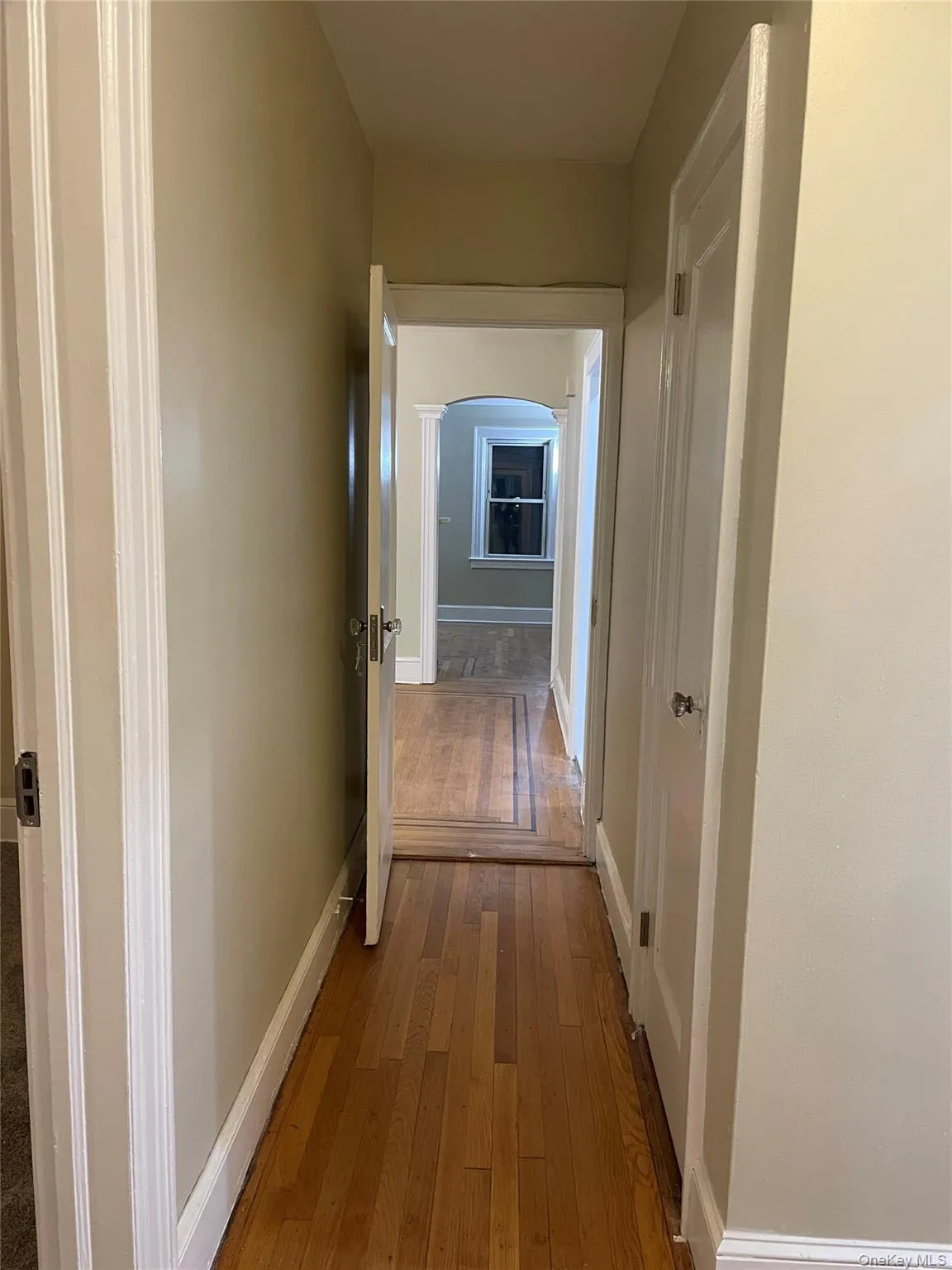 Hall with dark wood finished floors and arched walkways Hall with dark wood finished floors and arched walkways