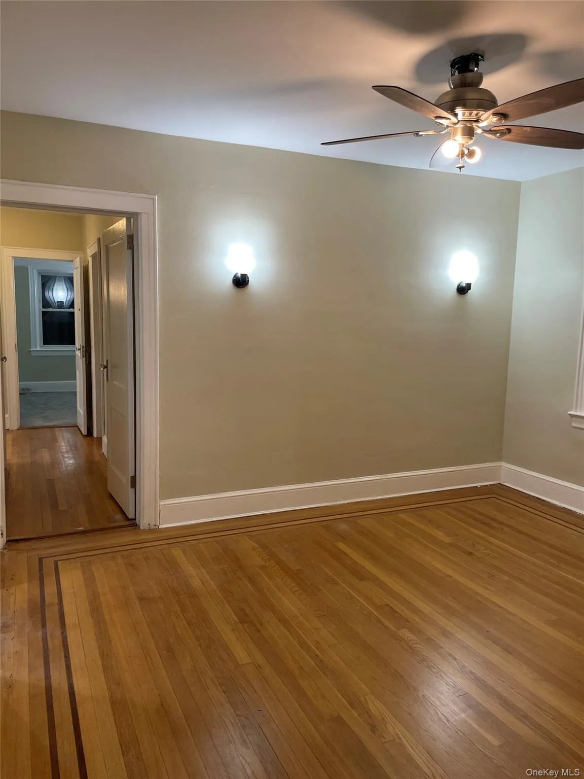 Spare room featuring dark wood-style flooring and ceiling fan Spare room featuring dark wood-style flooring and ceiling fan