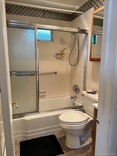 Full bathroom with enclosed tub / shower combo, vanity, and tile patterned flooring Full bathroom with enclosed tub / shower combo, vanity, and tile patterned flooring