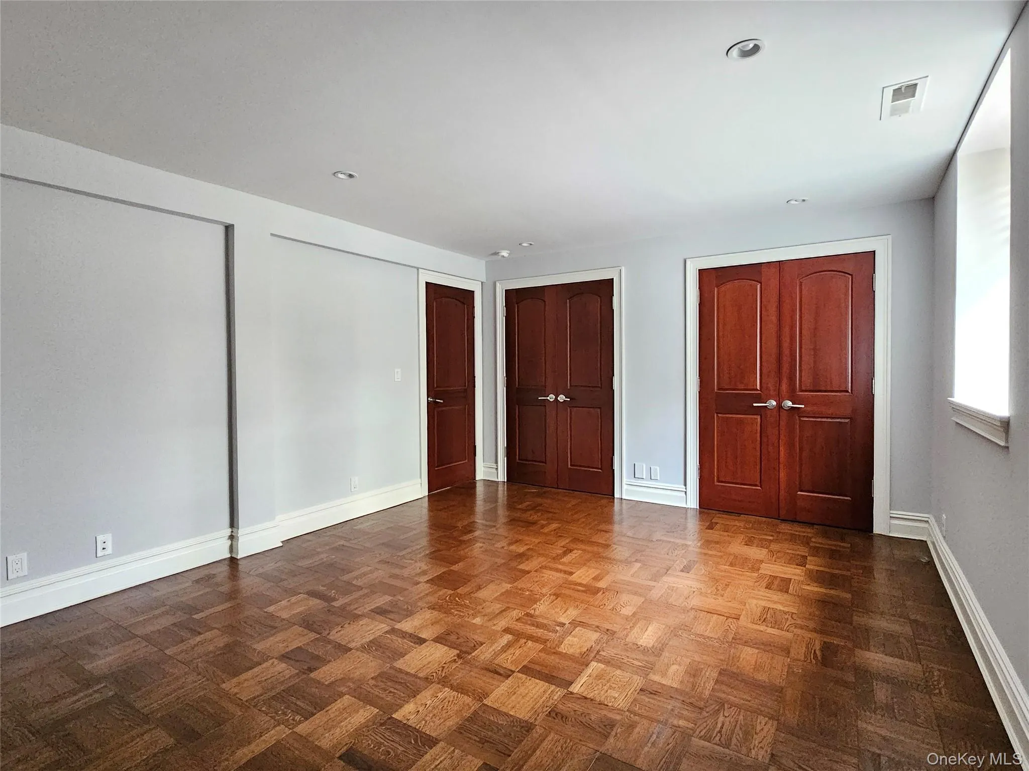 Unfurnished bedroom with multiple closets and baseboards Unfurnished bedroom with multiple closets and baseboards