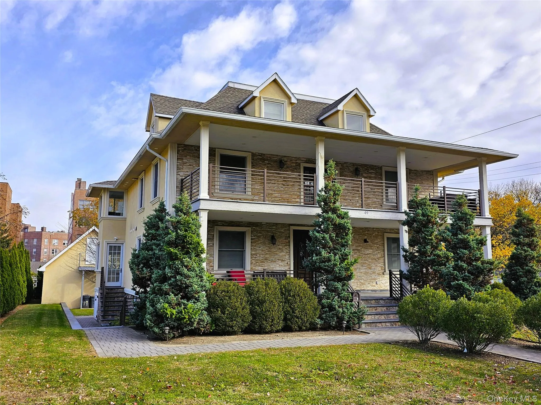 View of front of home featuring covered porch, stone siding, and a front yard View of front of home featuring covered porch, stone siding, and a front yard