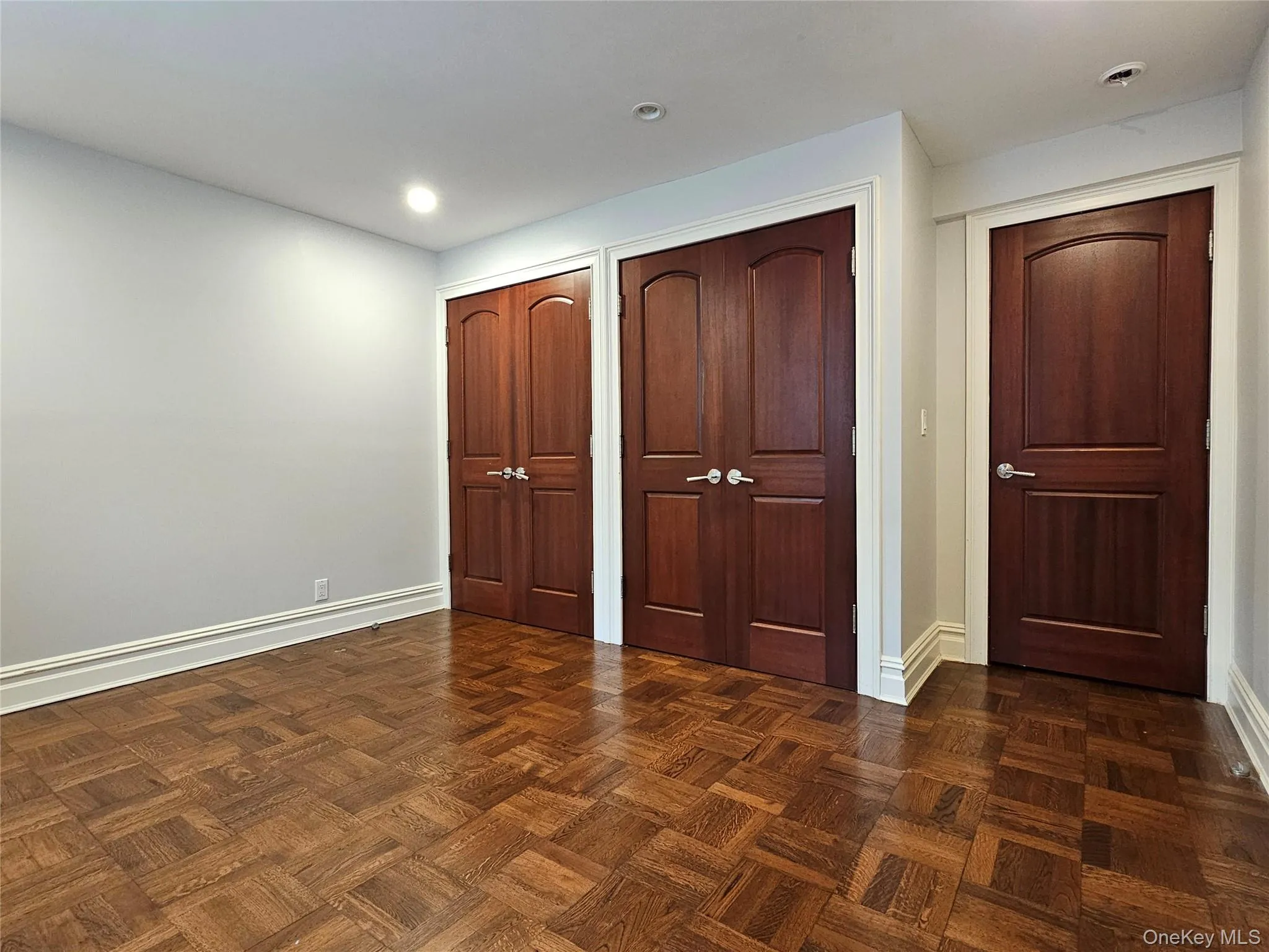Unfurnished bedroom with two closets and recessed lighting Unfurnished bedroom with two closets and recessed lighting