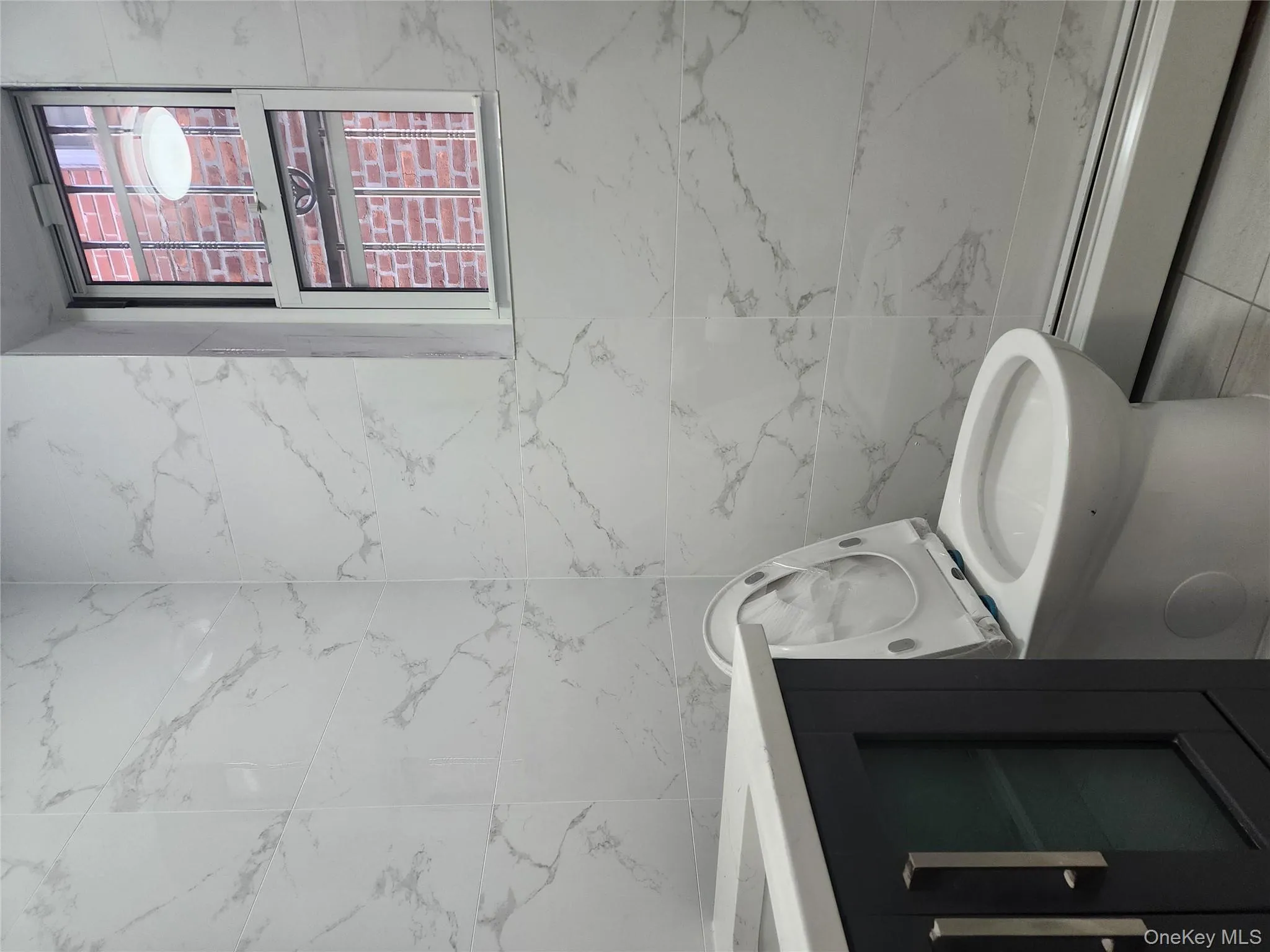 Bathroom featuring vanity, a baseboard heating unit, tile walls, and a shower stall Bathroom featuring vanity, a baseboard heating unit, tile walls, and a shower stall