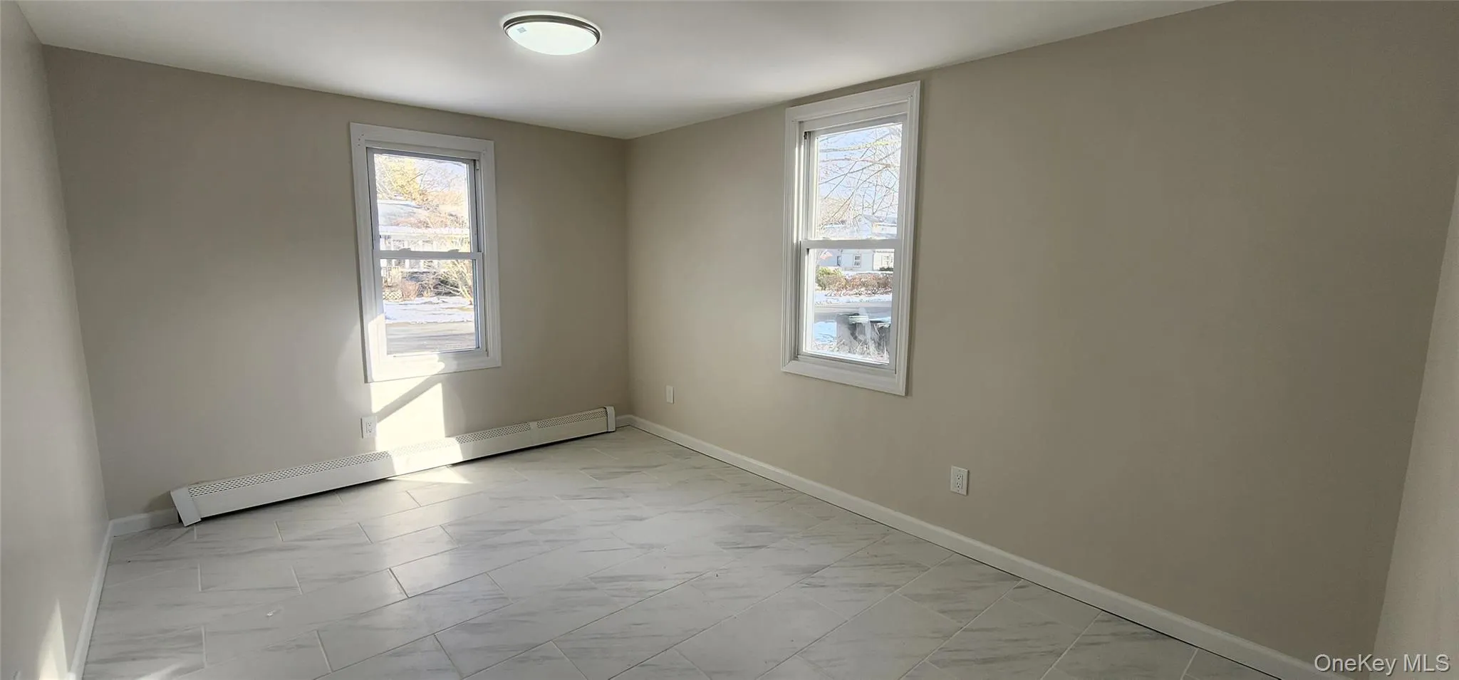 Empty room featuring baseboard heating and baseboards Empty room featuring baseboard heating and baseboards