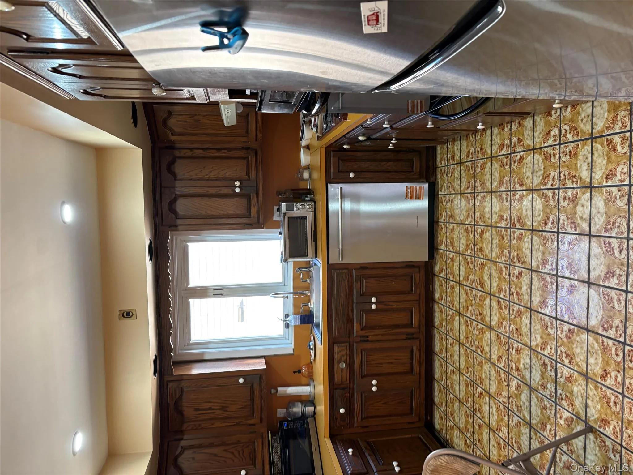 Kitchen with dark brown cabinetry, stainless steel appliances, light countertops, and recessed lighting Kitchen with dark brown cabinetry, stainless steel appliances, light countertops, and recessed lighting