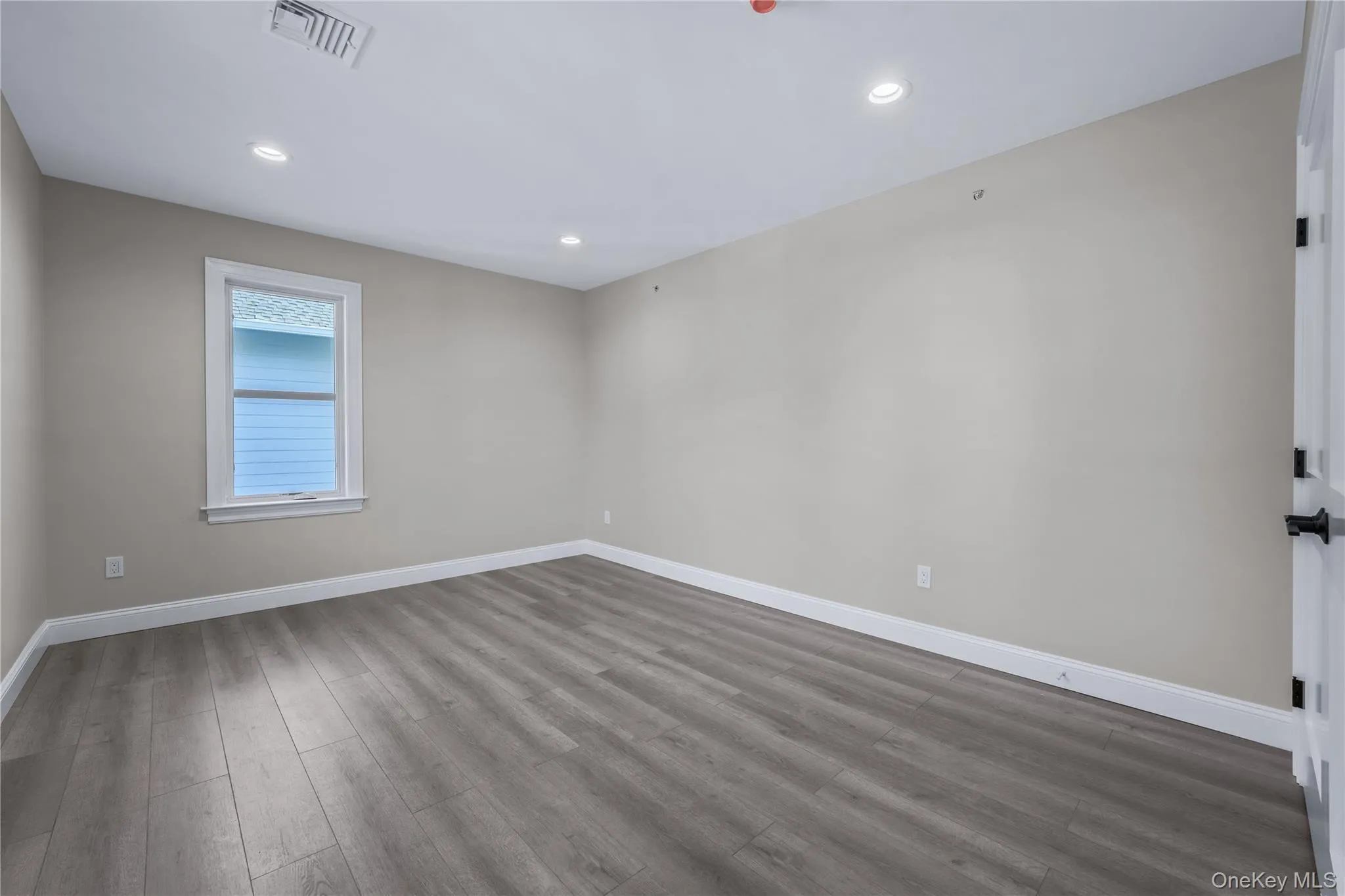 Unfurnished room with wood finished floors and recessed lighting Unfurnished room with wood finished floors and recessed lighting