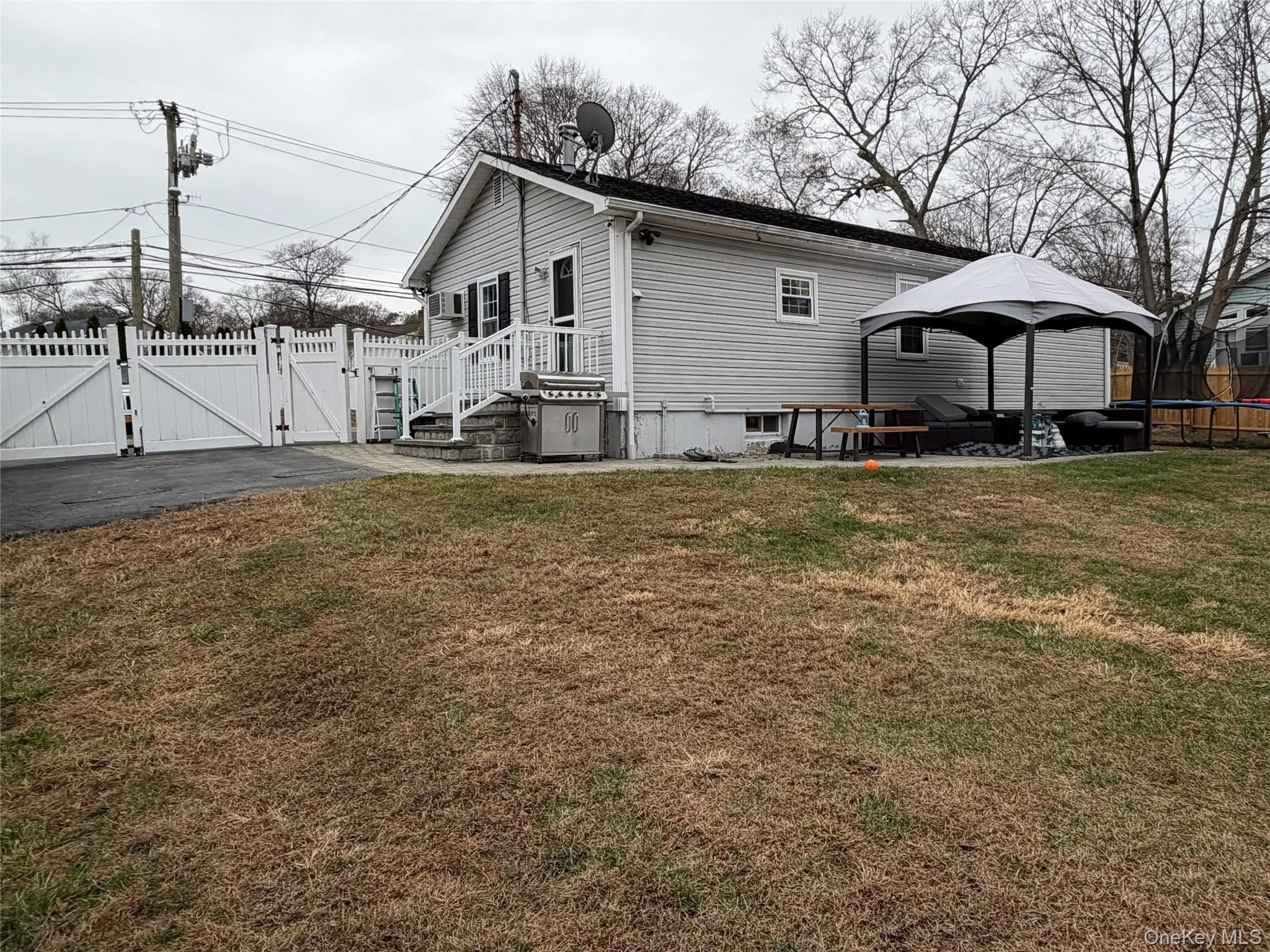 Back of house with a gate, a patio area, and a gazebo Back of house with a gate, a patio area, and a gazebo